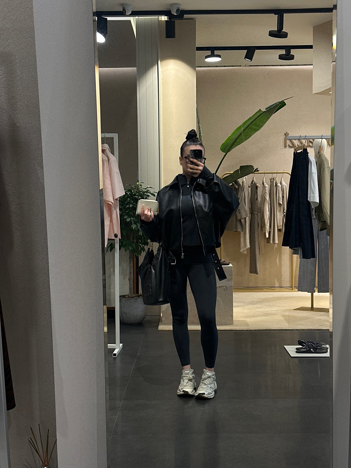 Woman takes mirror selfie in Sofia clothing store