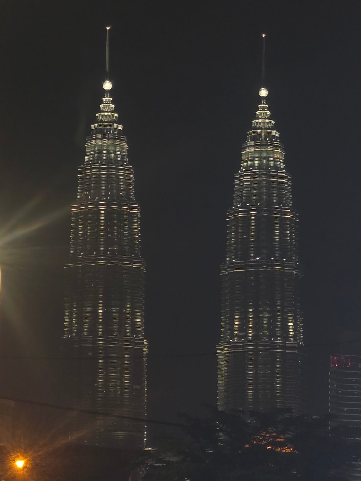 Petronas Twin Towers nighttime reflection captured in Kuala Lumpur