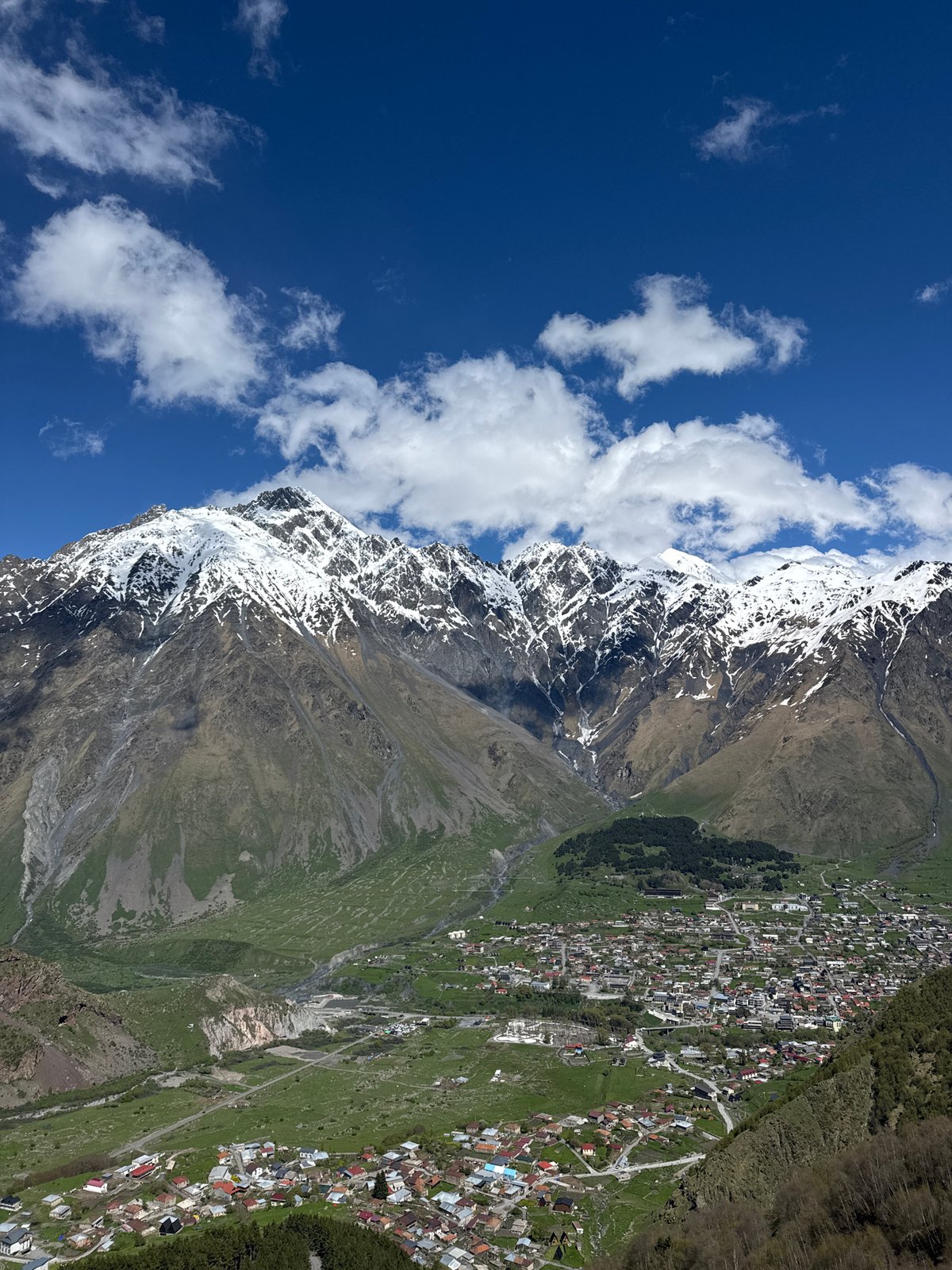 Tourist visits historic Gergeti Trinity Church in Georgian mountains