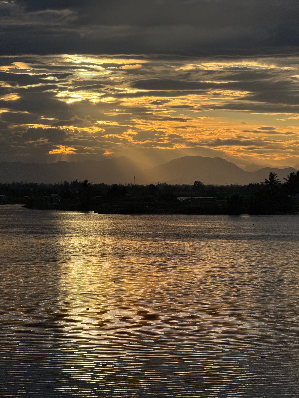 Golden hour light over a calm river in Hoi An
