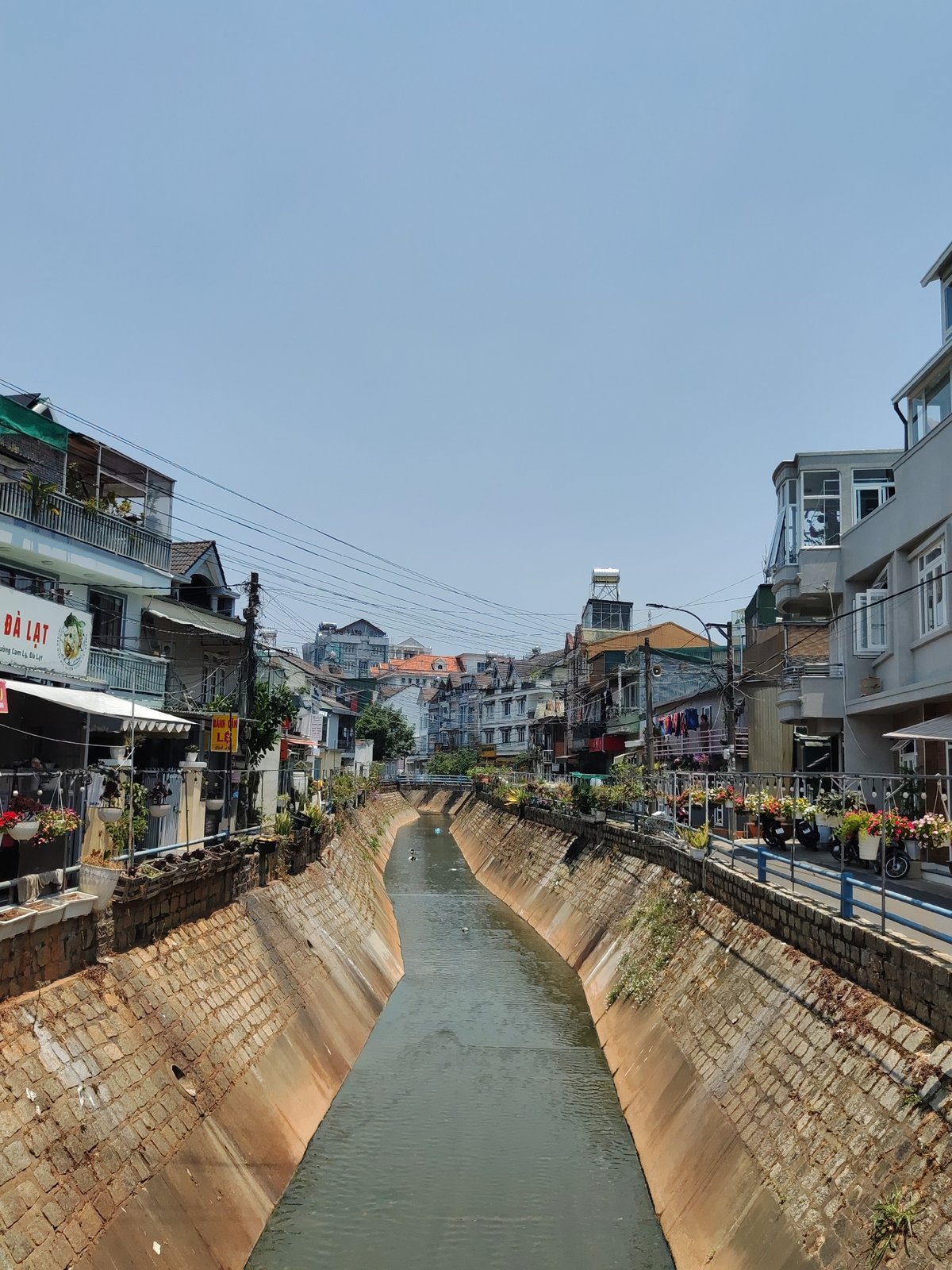 Stone canal flows through Cam Ly district buildings