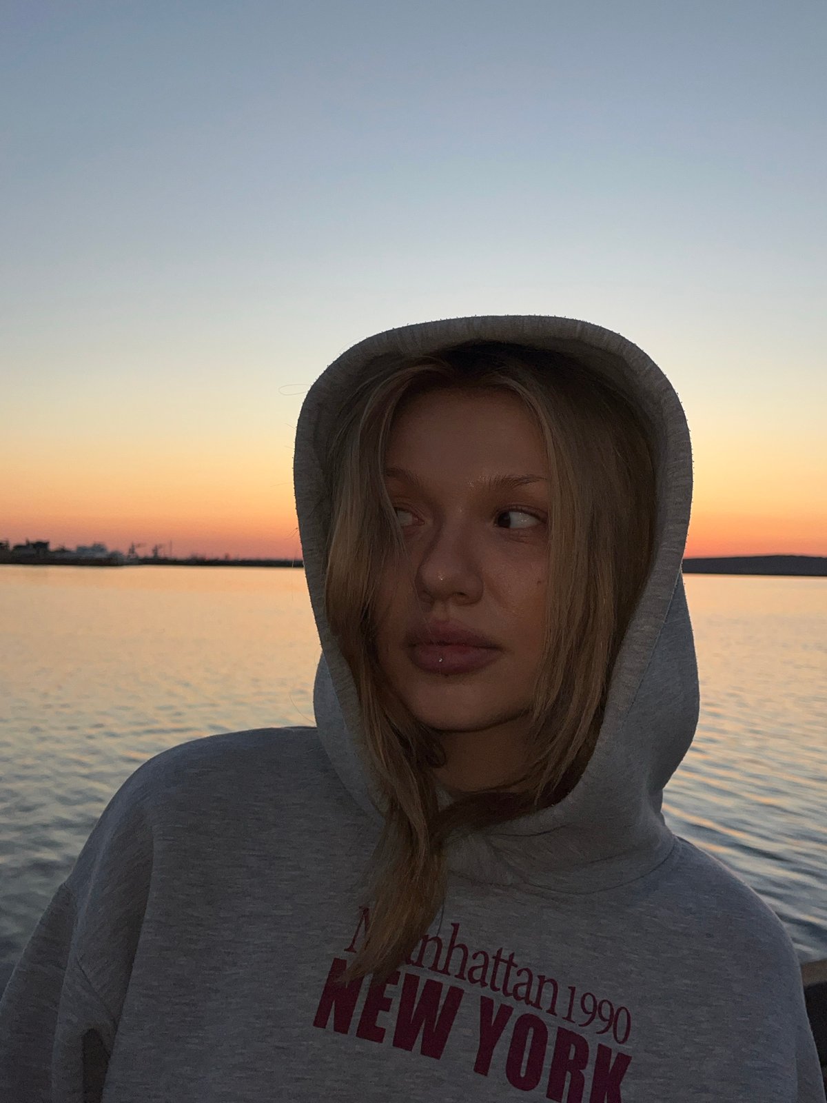 Two women photograph sunset poses by water in Chaikovsky