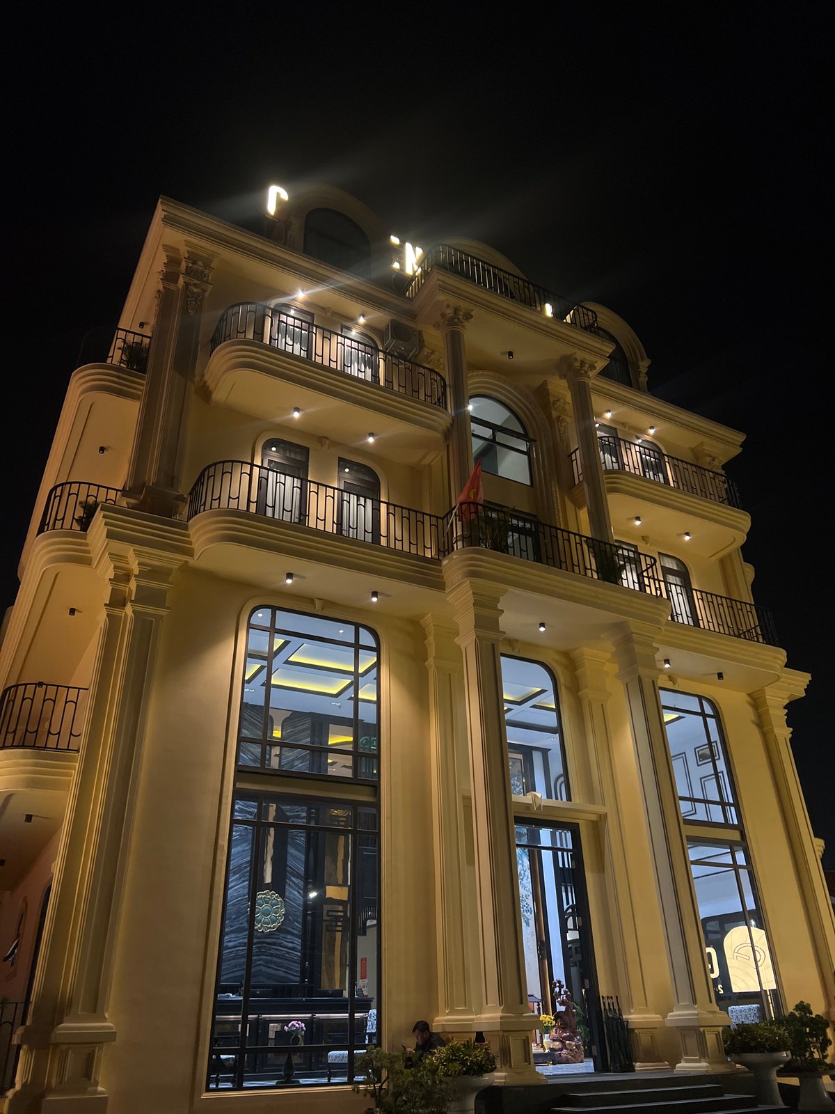Illuminated yellow building photographed at night in Da Lat