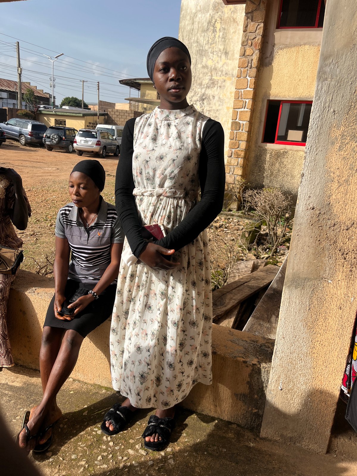 Church gathering outside in Bukuru, Nigeria, offering envelopes in hand