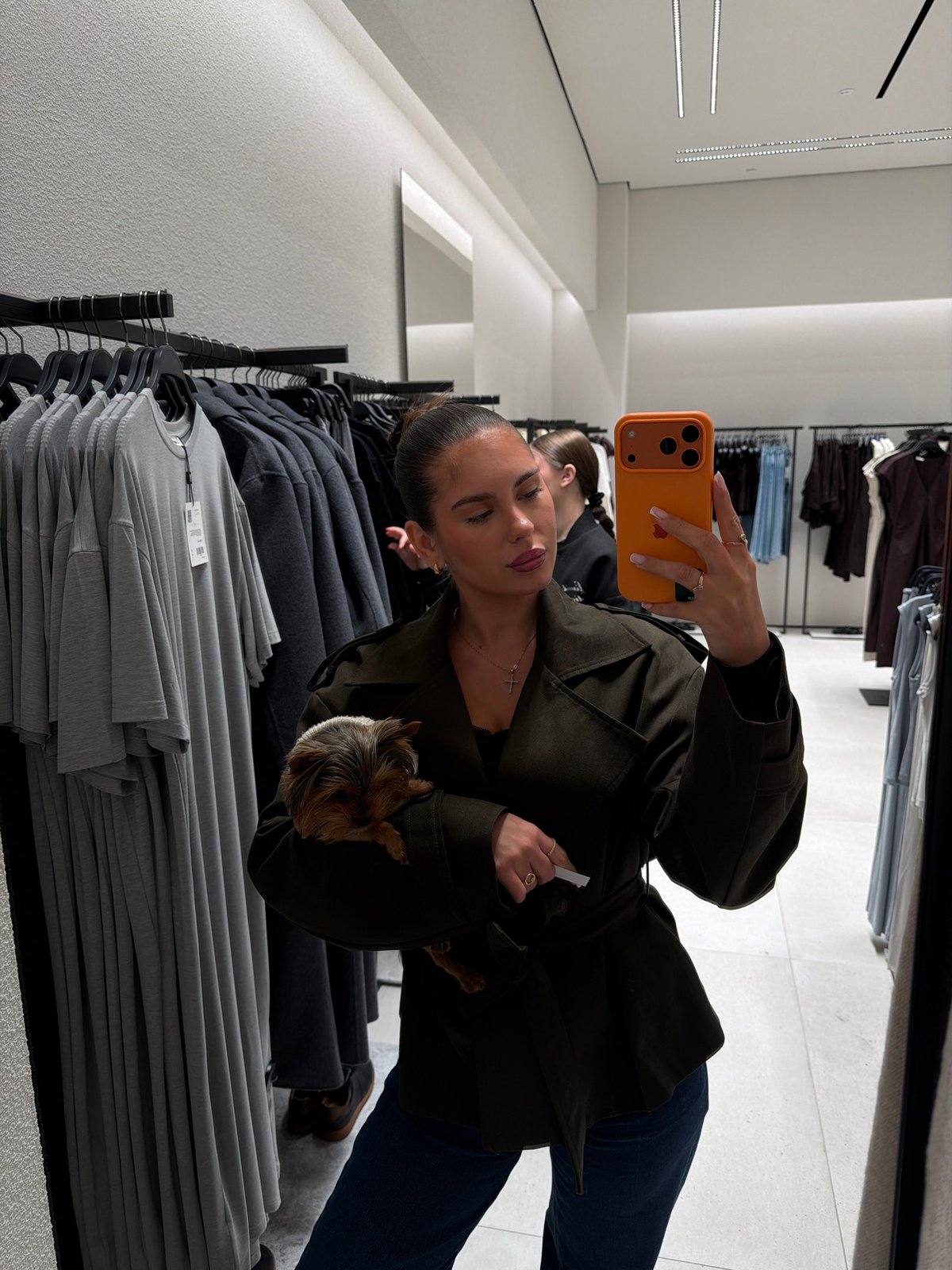 Woman takes selfie with dog in jacket at Krasnoyarsk store