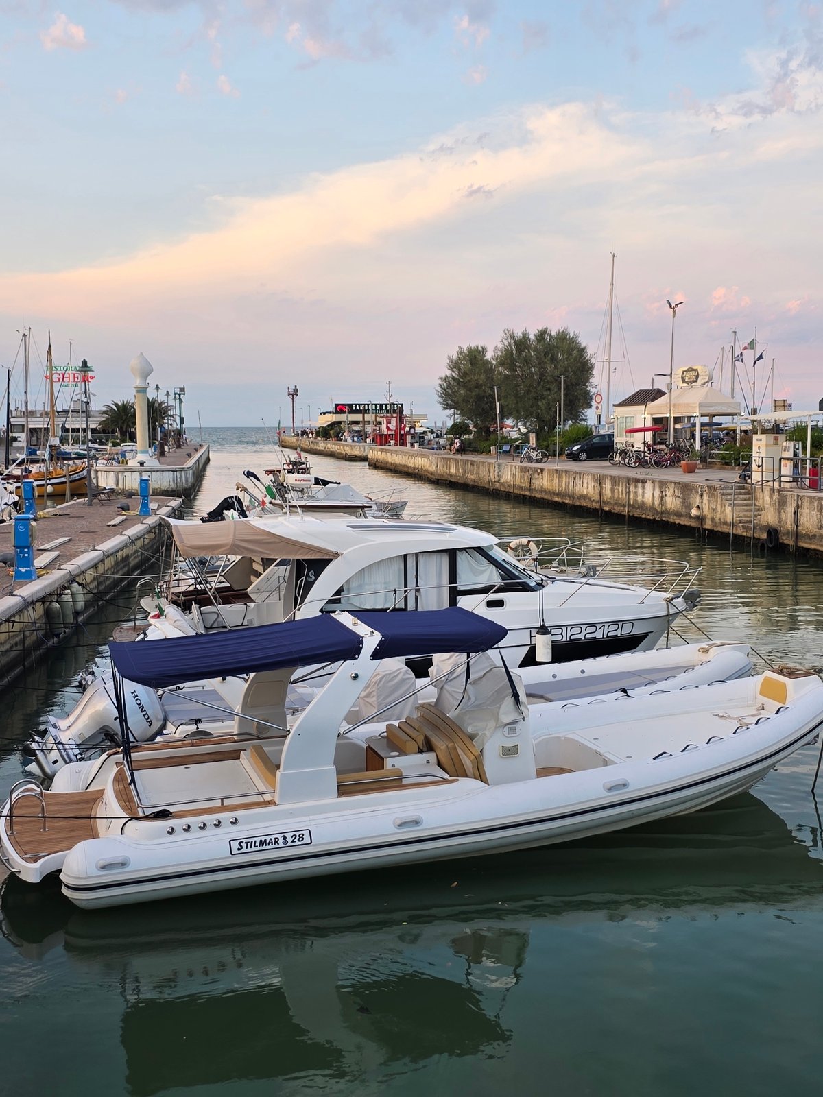 Boats docked at sunset along Riccione's harbor promenade