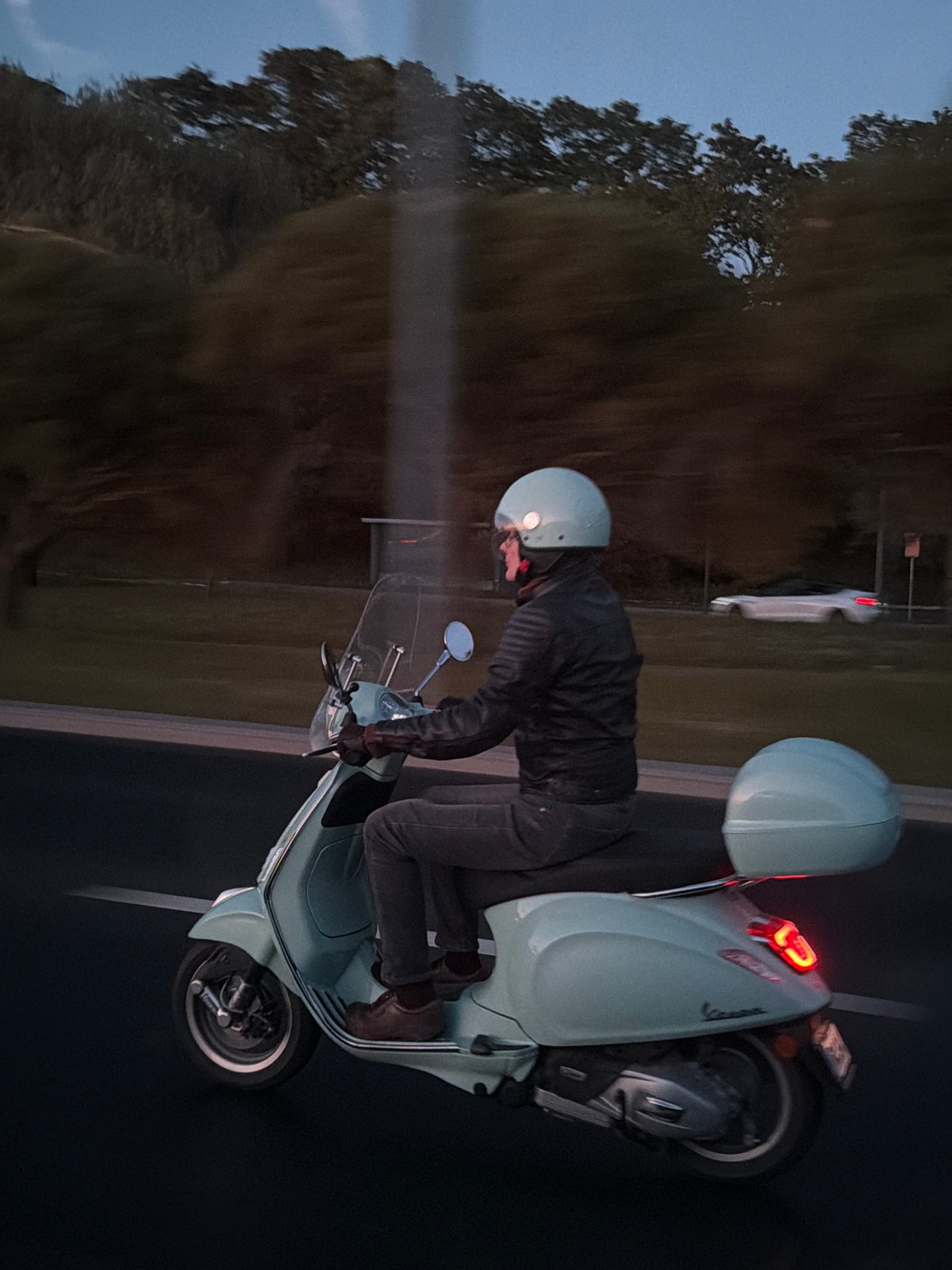 Scooter navigates wet Tallinn streets amid evening traffic