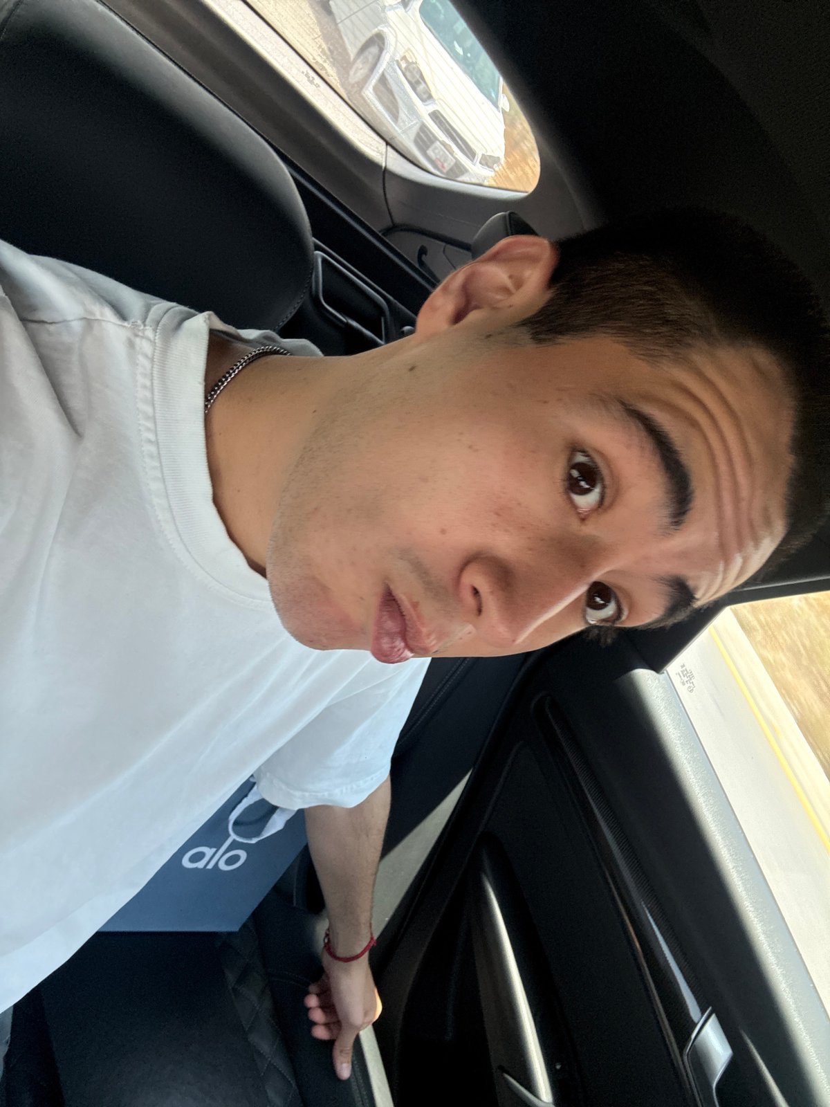 Young man takes selfie in car passenger seat