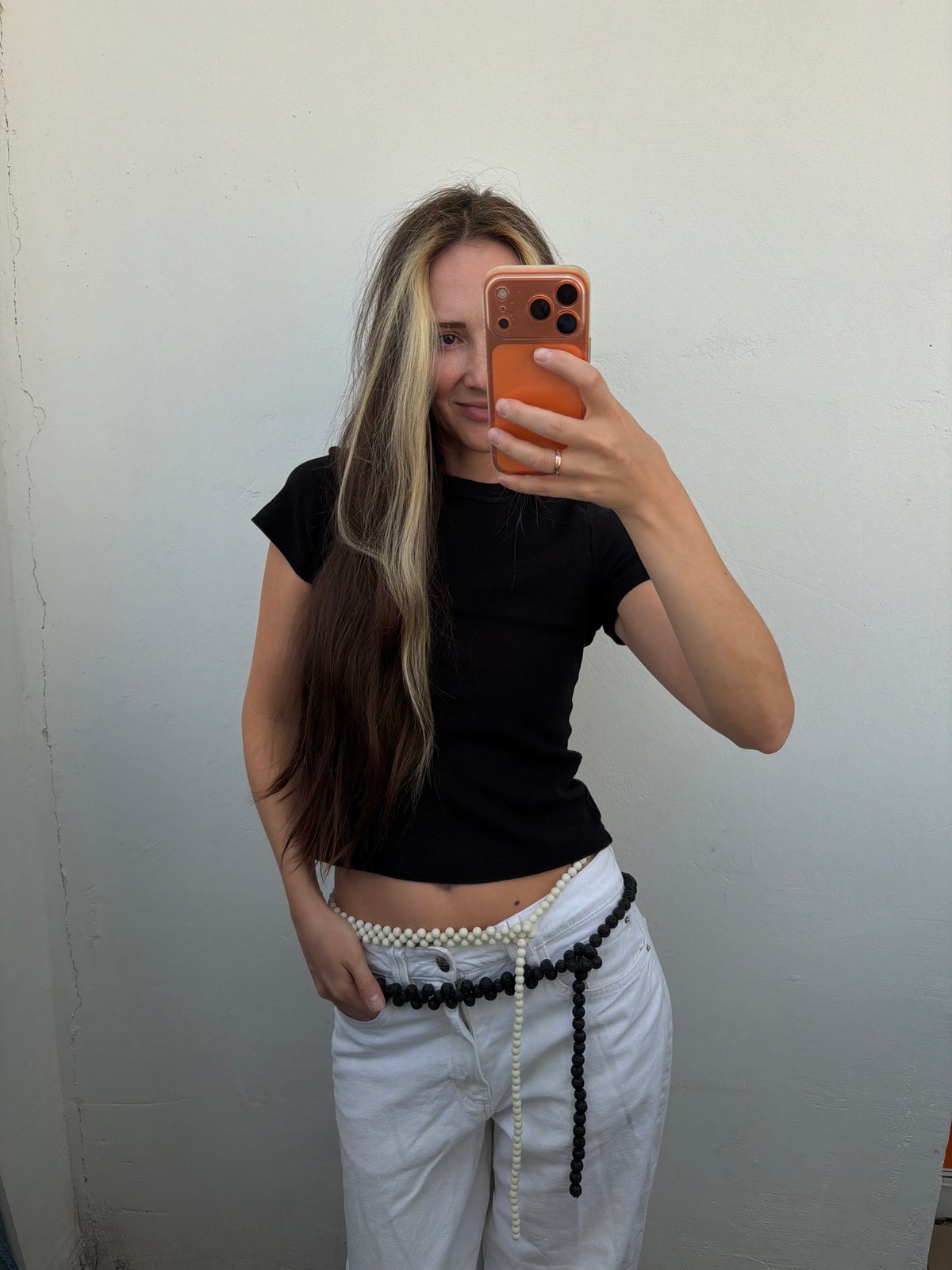 Woman takes selfies against wall in Khimki, Russia