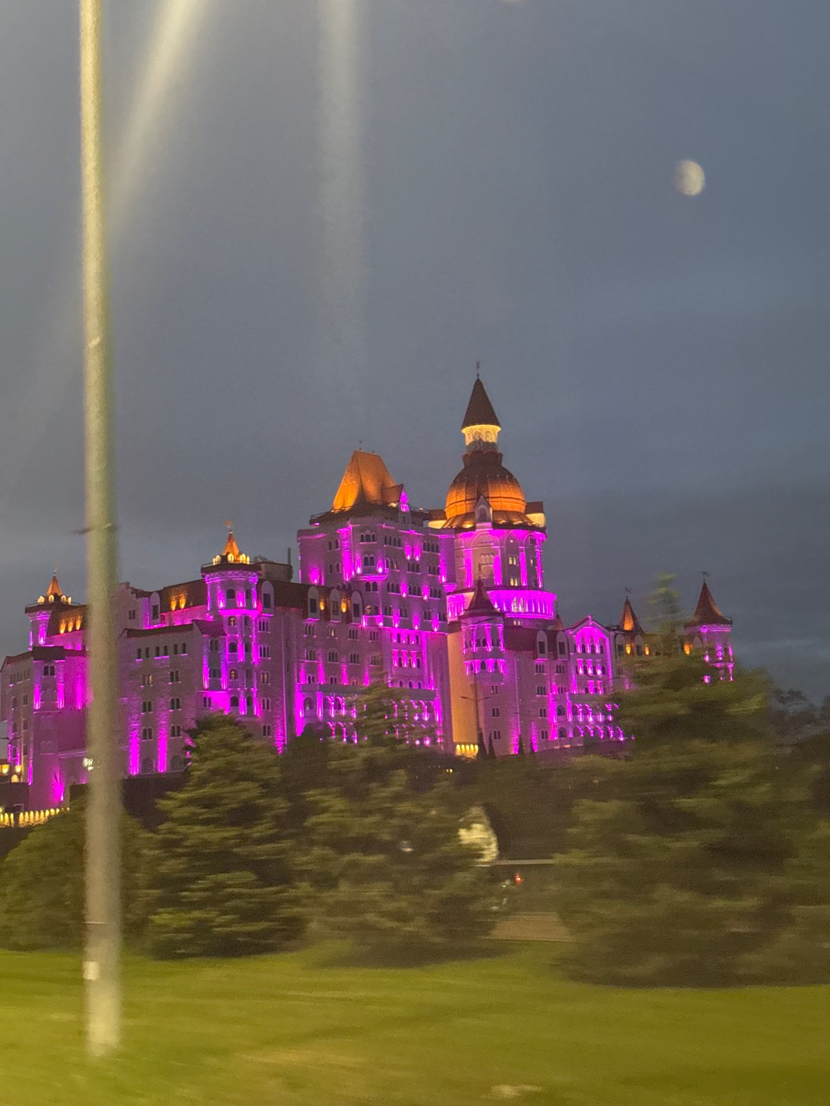 Bogatyr Castle Hotel illuminated in purple lights, Sirius Russia