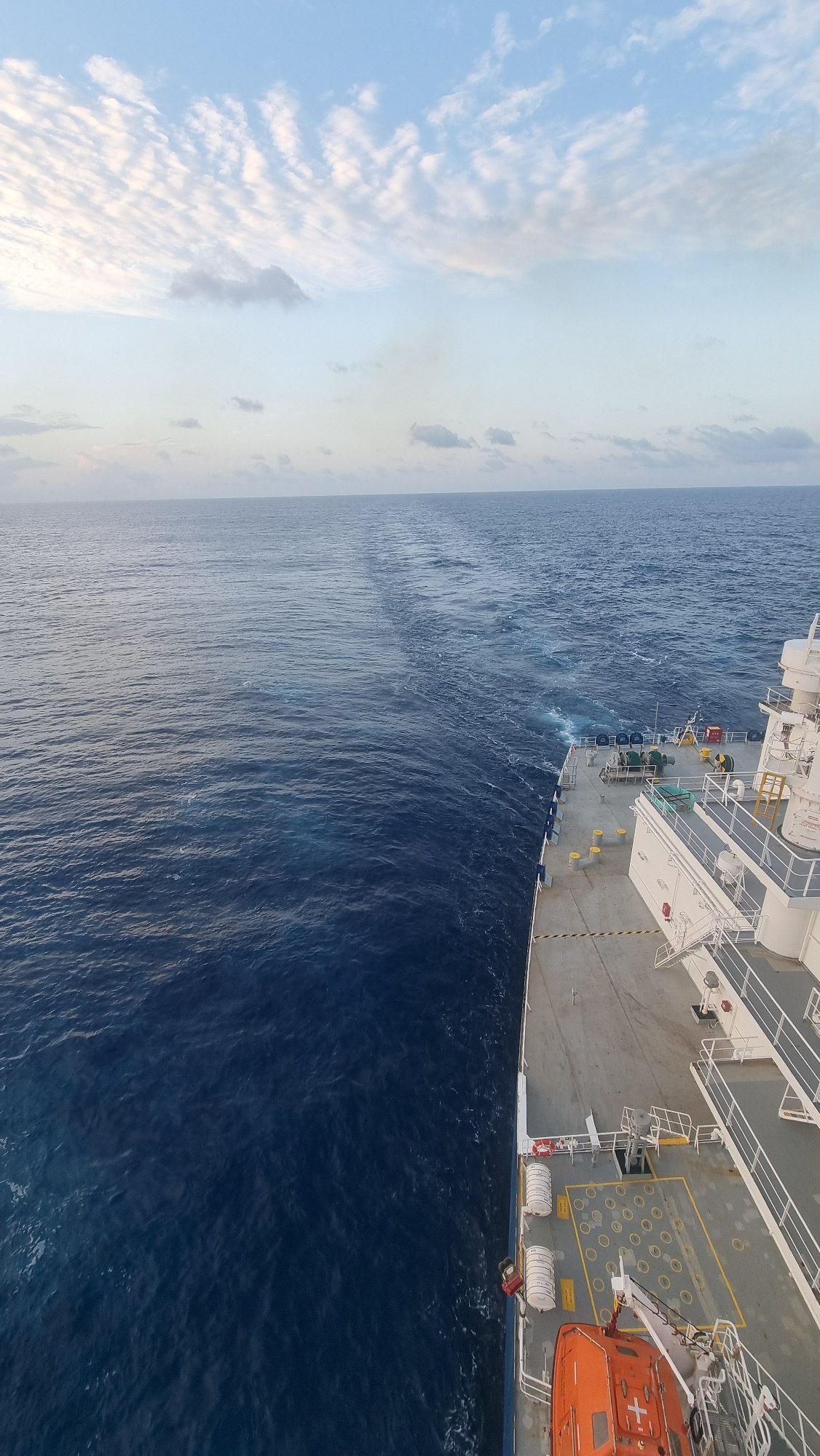 Ship cuts through deep blue Arabian Sea, wake trailing behind