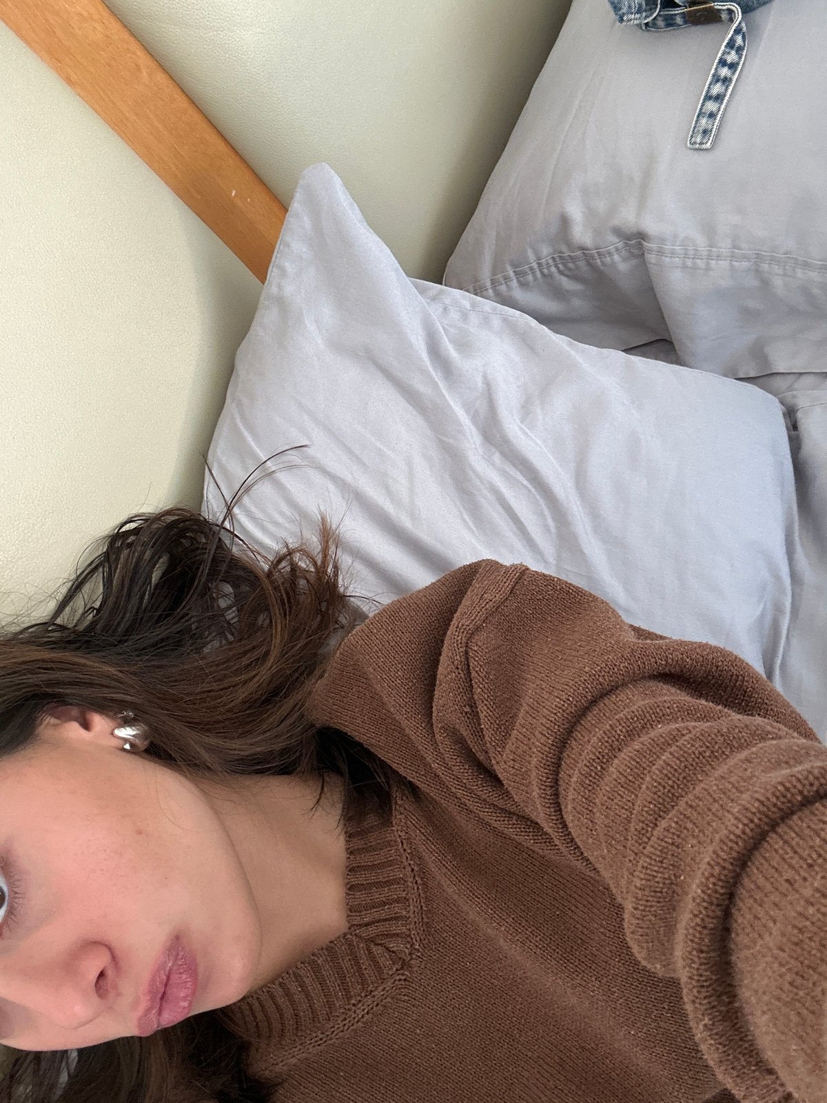 Person in brown sweater resting on bed captured multiple angles