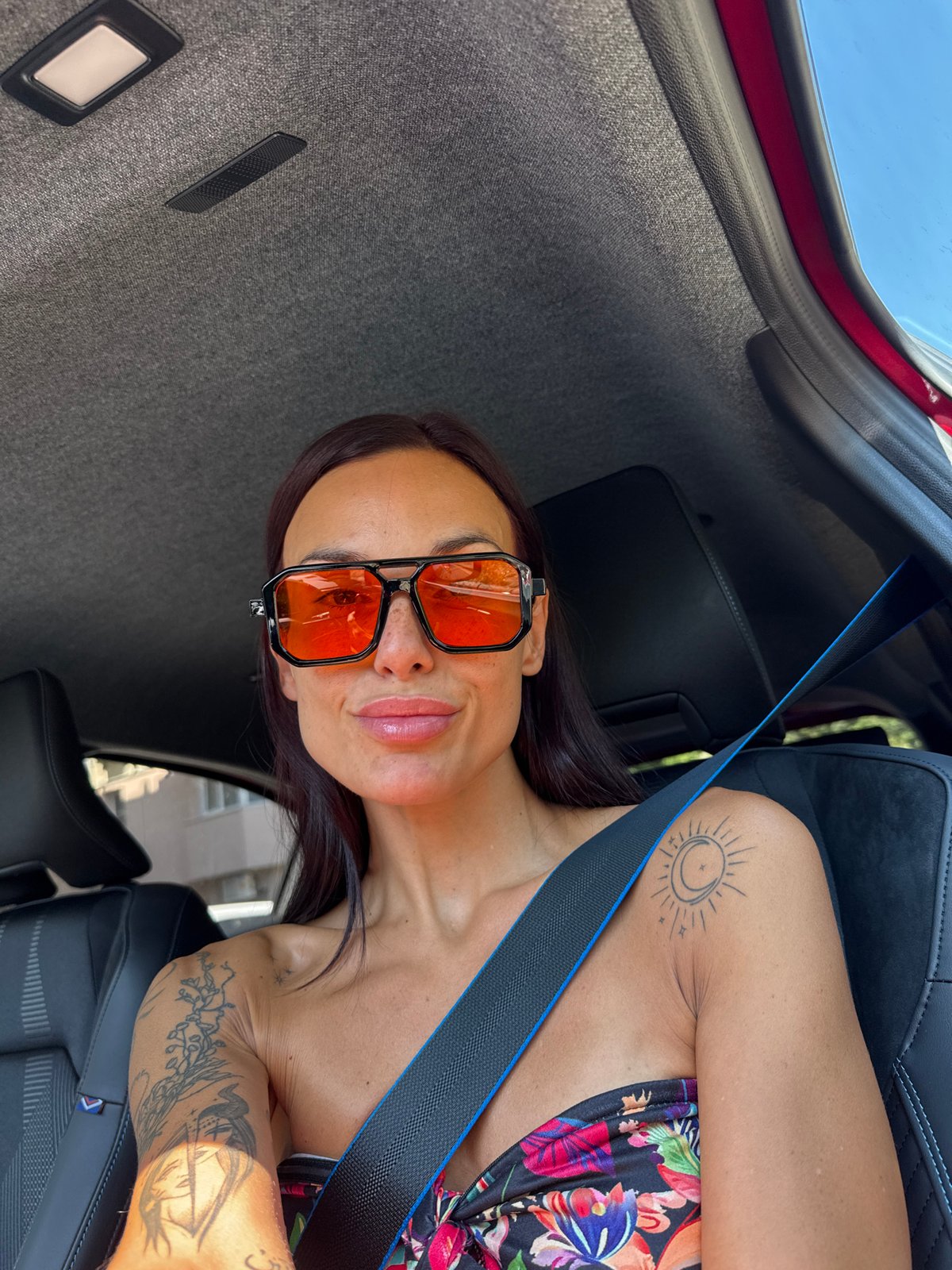 Passenger in orange shades and floral top, Pleven car interior