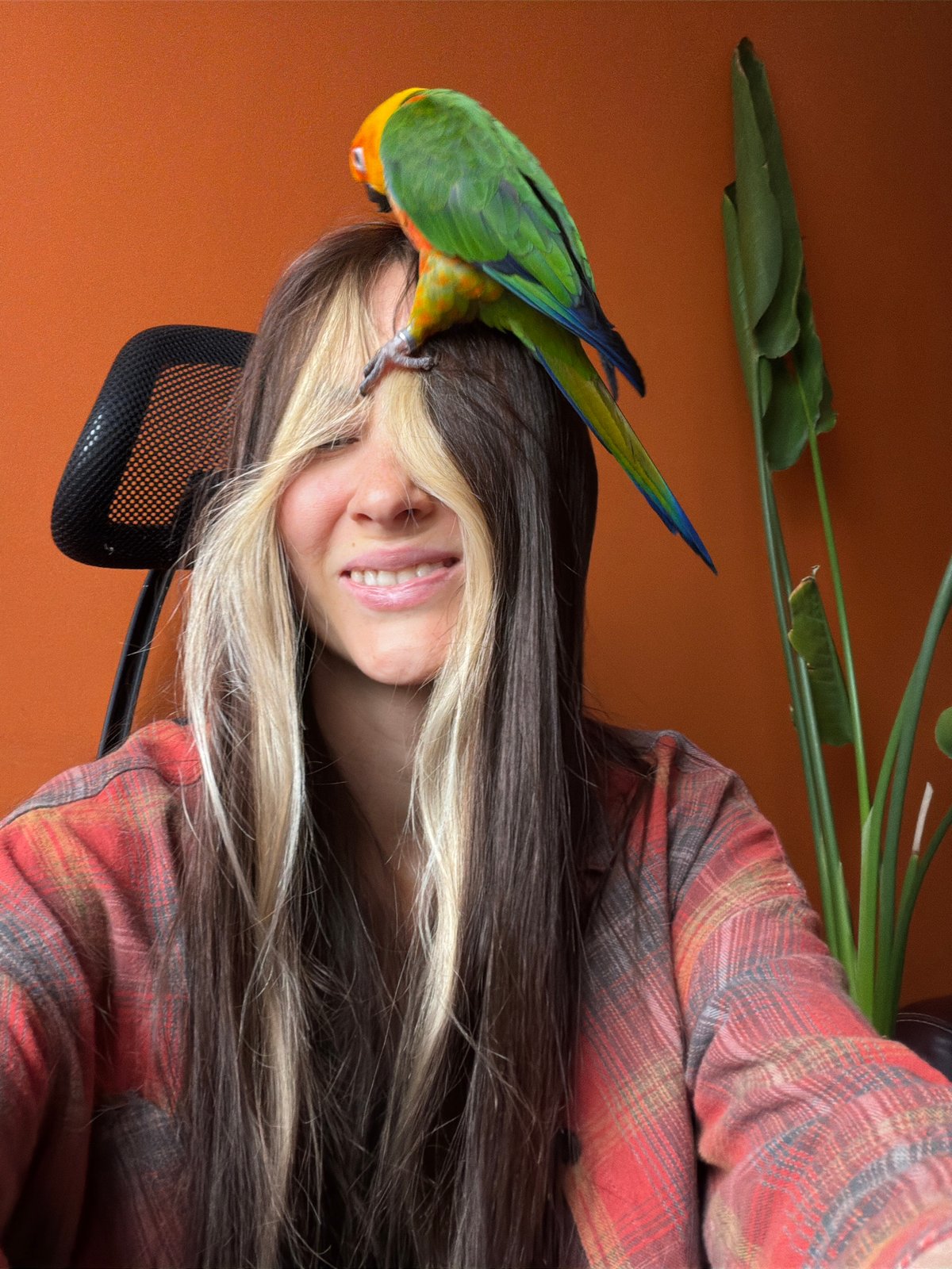 Woman poses with colorful parrot in Khimki home