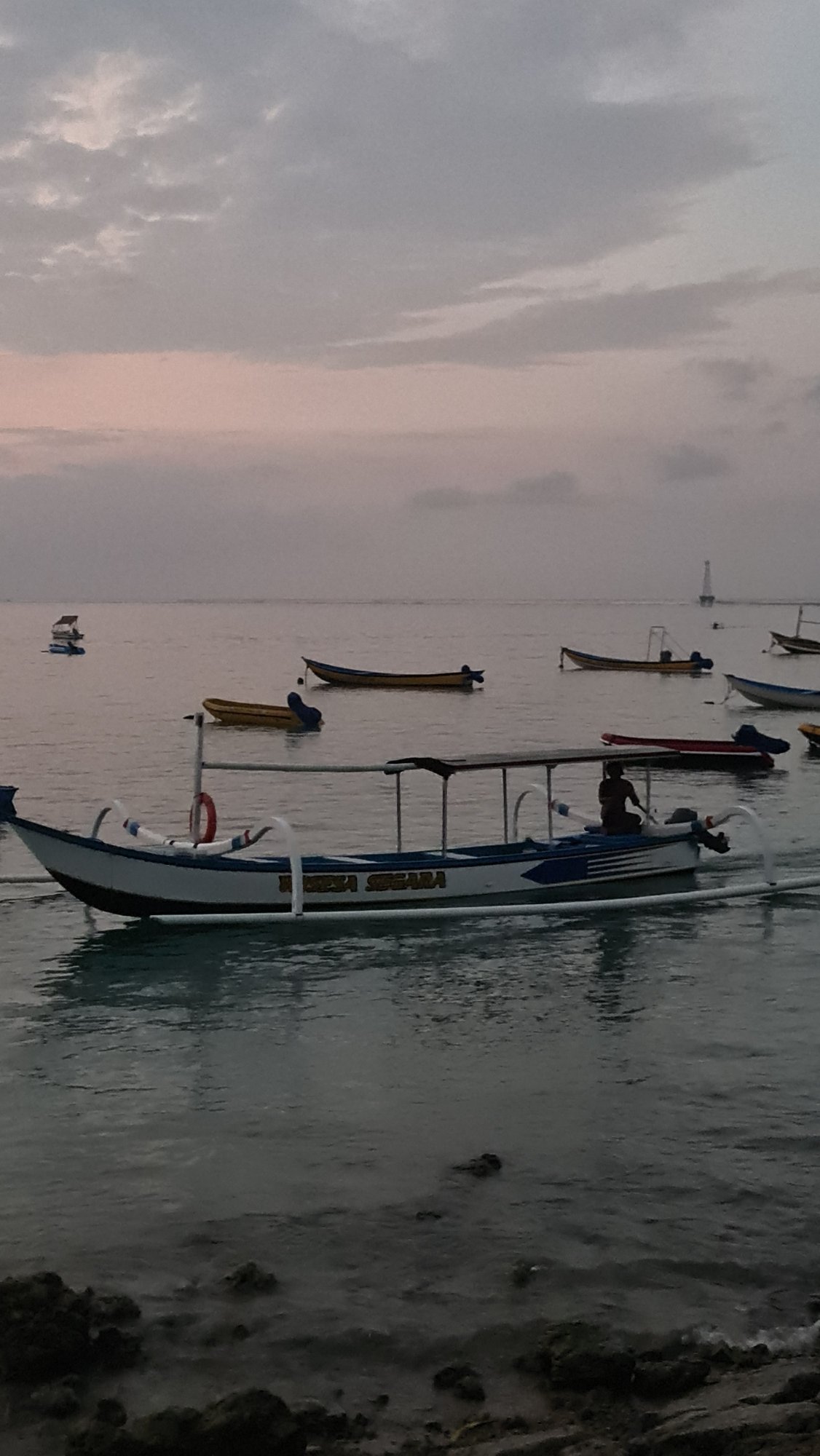 Dusk at Sanur Beach: surf lessons, boats, and shoreside gatherings