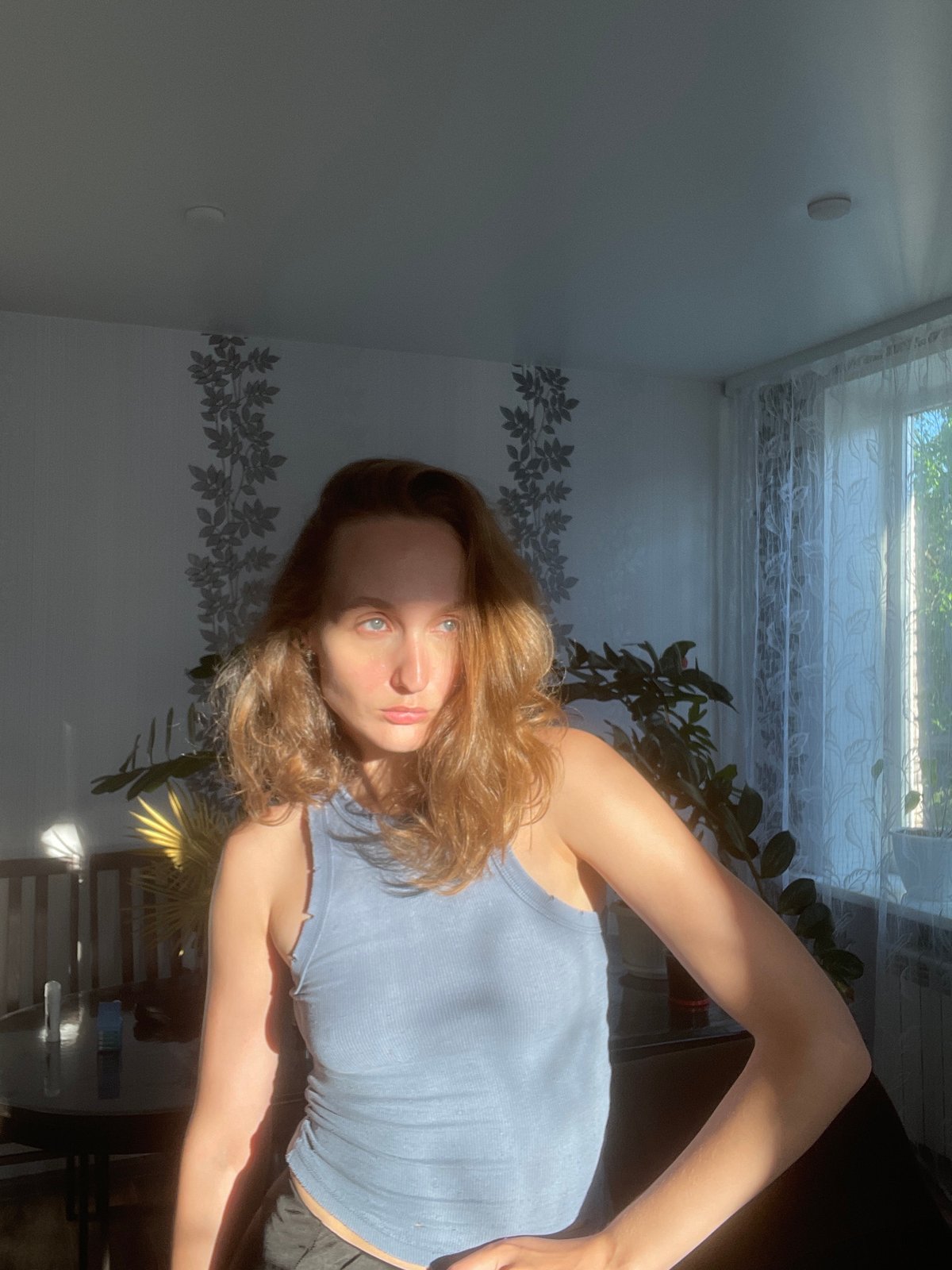 Woman photographs herself multiple times indoors in Sharkan, Russia