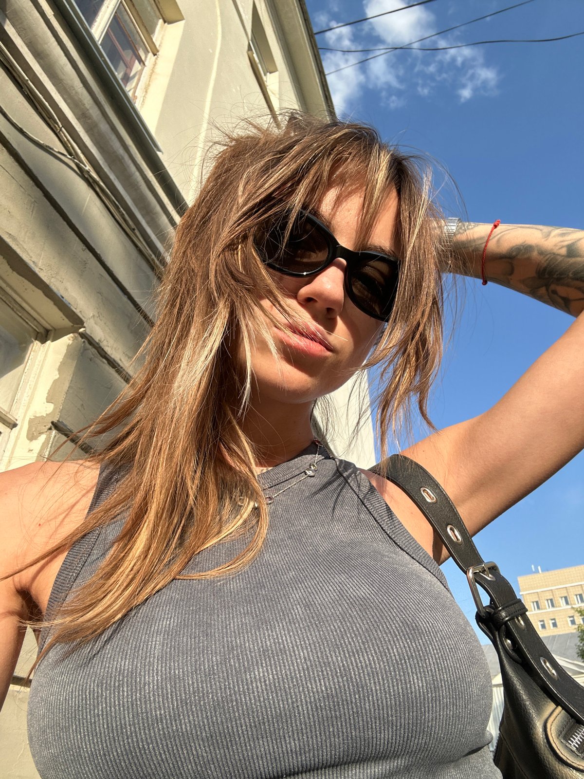 Woman takes selfie in Moscow wearing sunglasses and tank top