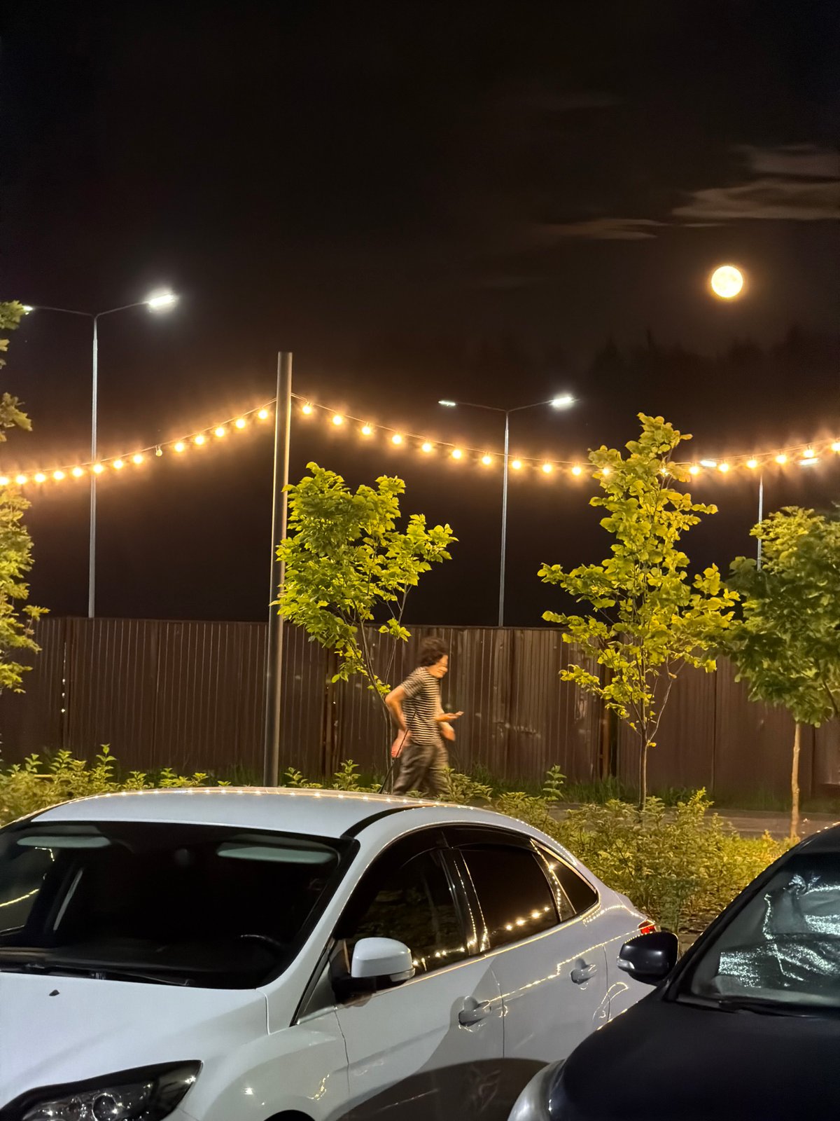 Full moon night at a Russian apartment complex parking lot