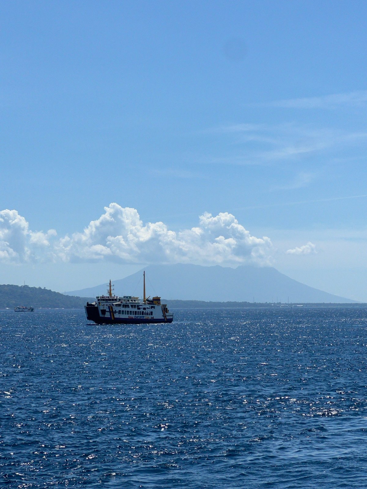 Ferry passengers document morning journey off Melaya, Indonesia coast