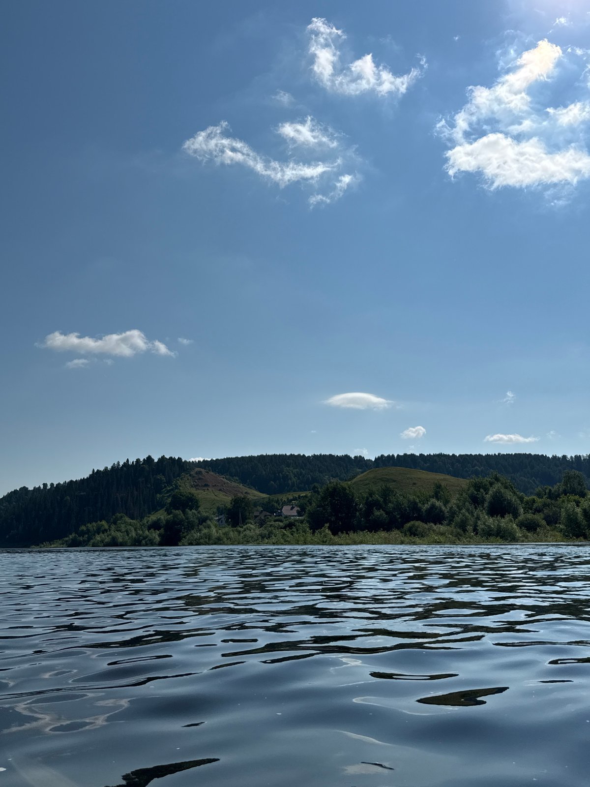 Tugboat and bulk cargo barge moving along the Ural River