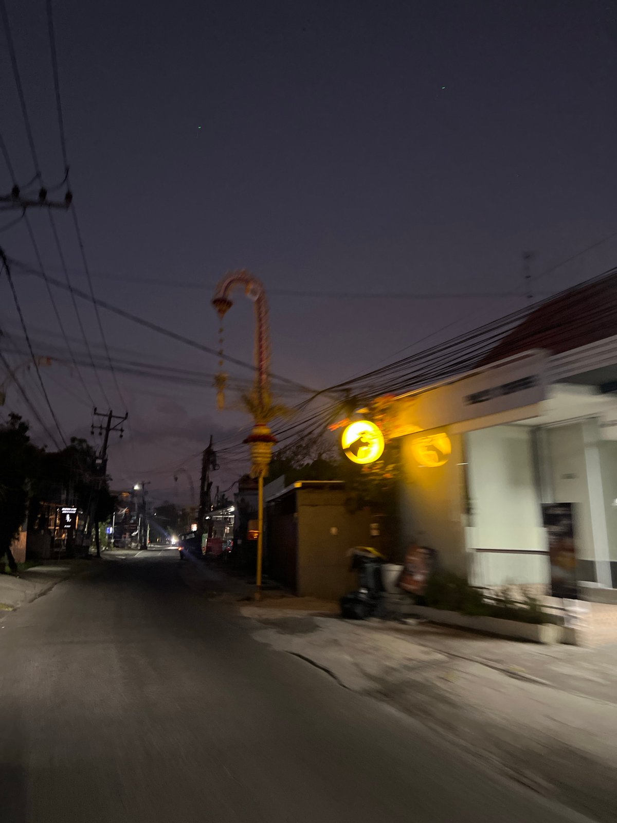 Dusk street scene in North Kuta with overhead power lines