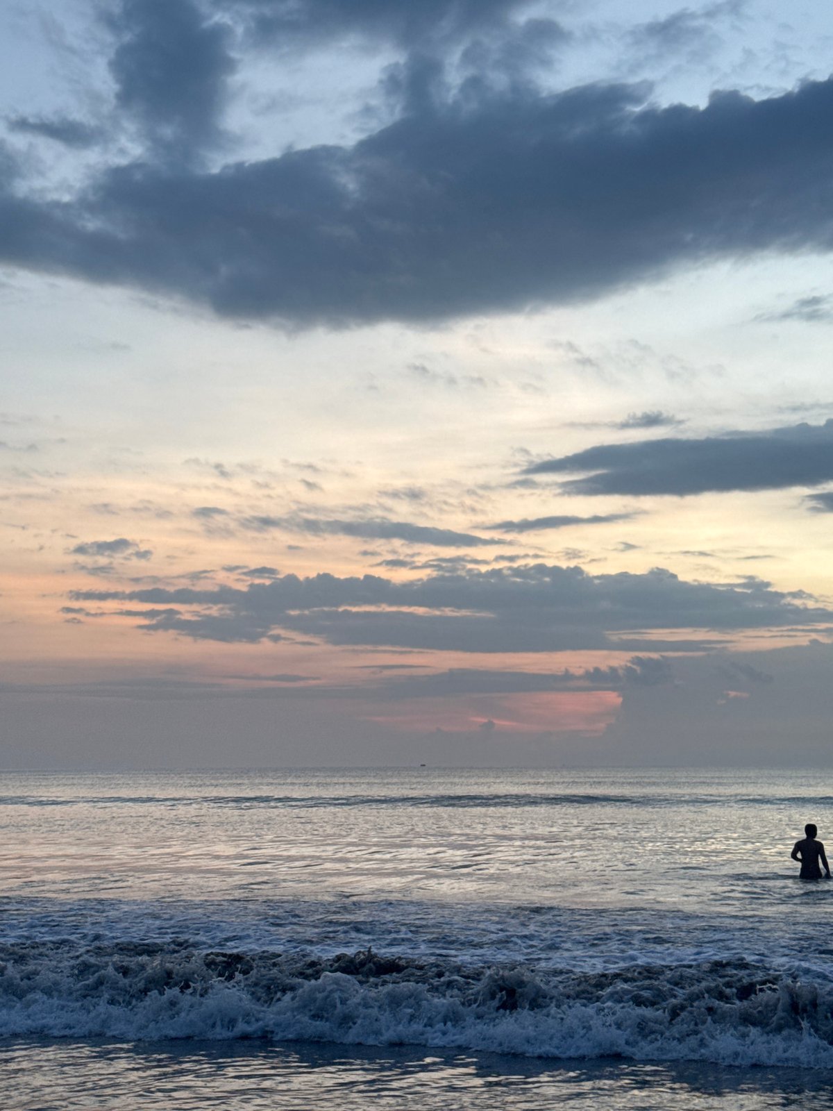 Swimmers enjoy sunset waters at Kuta Selatan beach