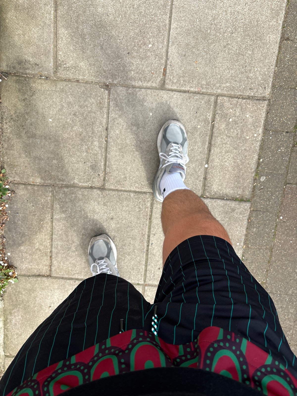 Person in running gear stands on London sidewalk