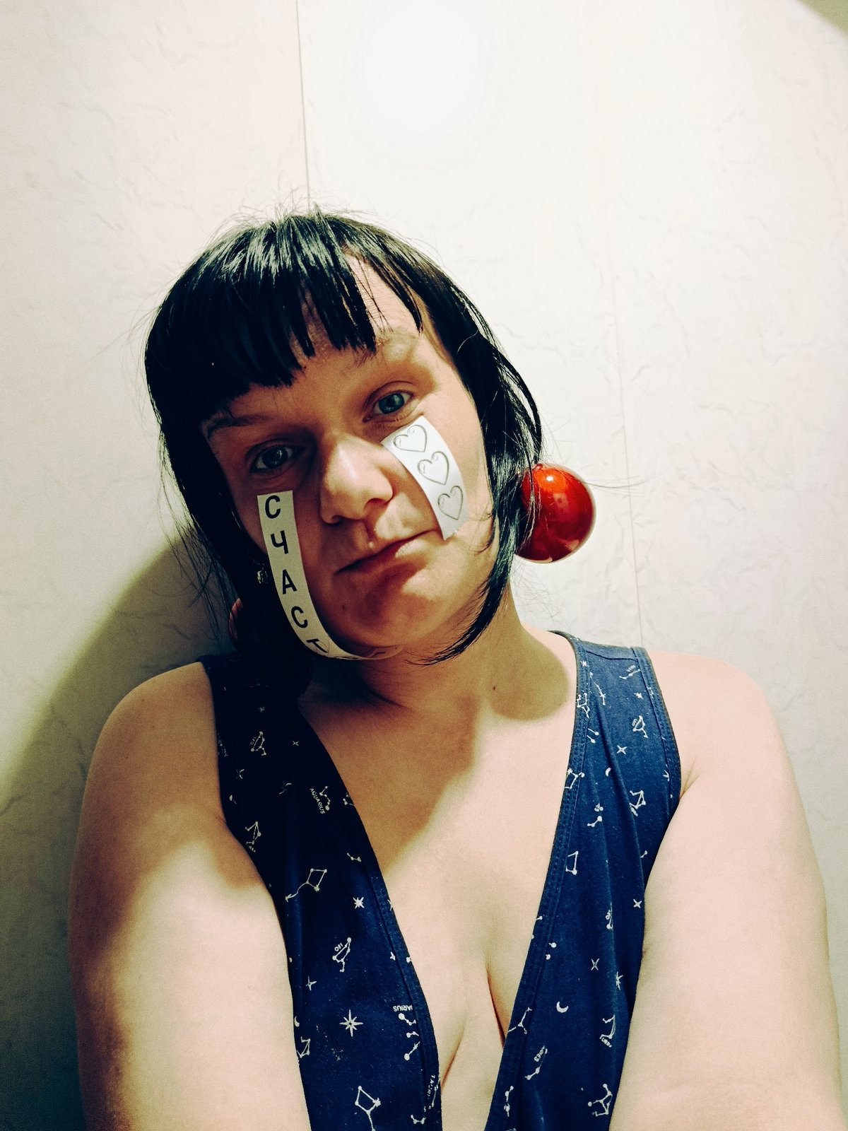 Person poses in constellation tank top with Cyrillic tape