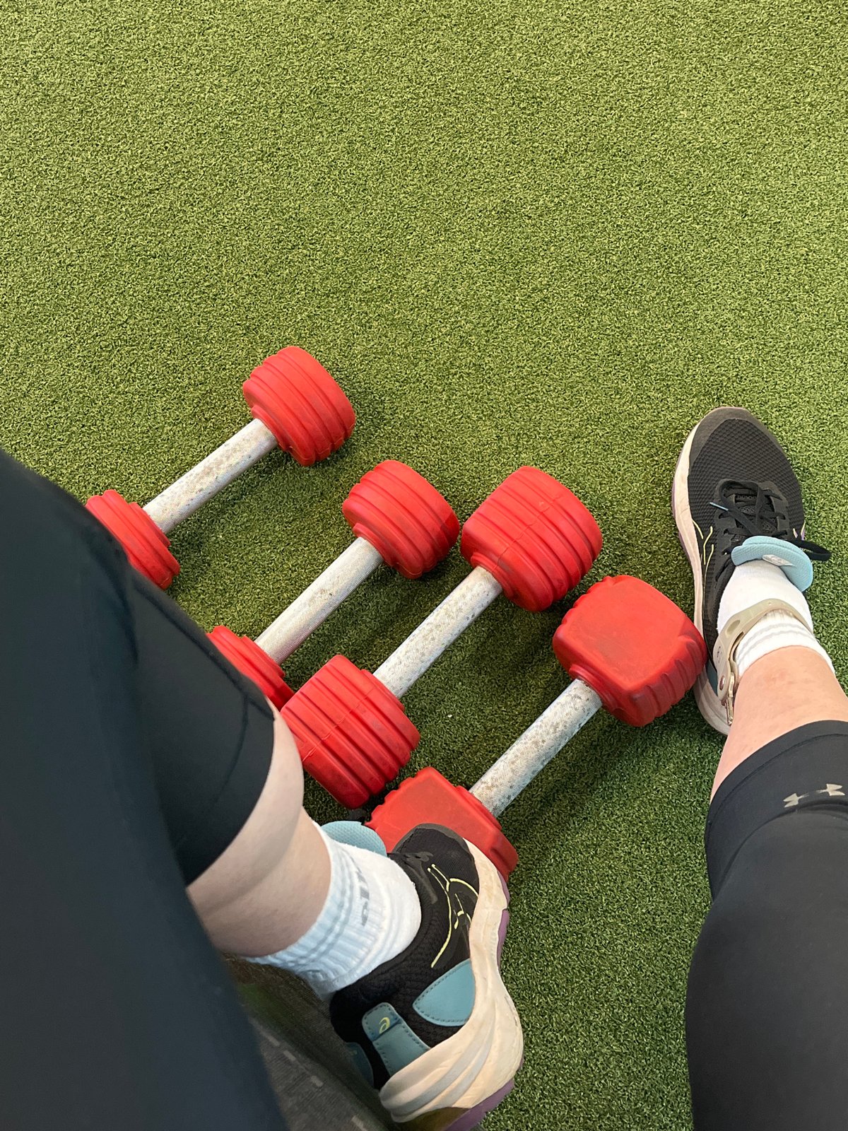 Outdoor dumbbell workout session captured on artificial turf