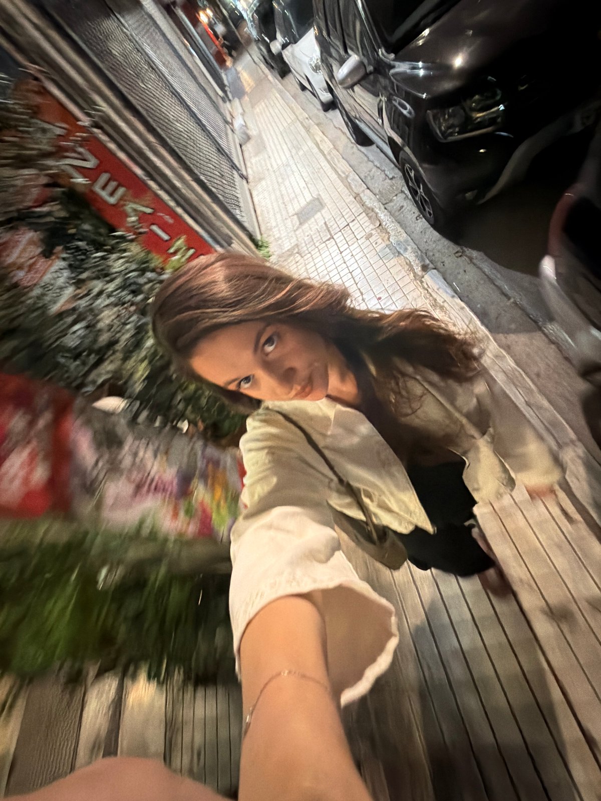 Woman takes selfies on Athens street at night