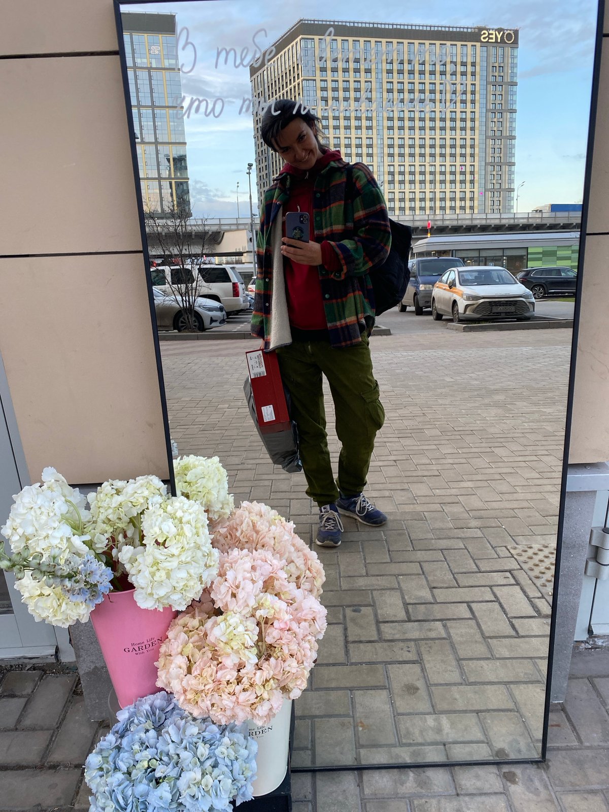 Person takes phone photo reflected in mirror on Moscow sidewalk