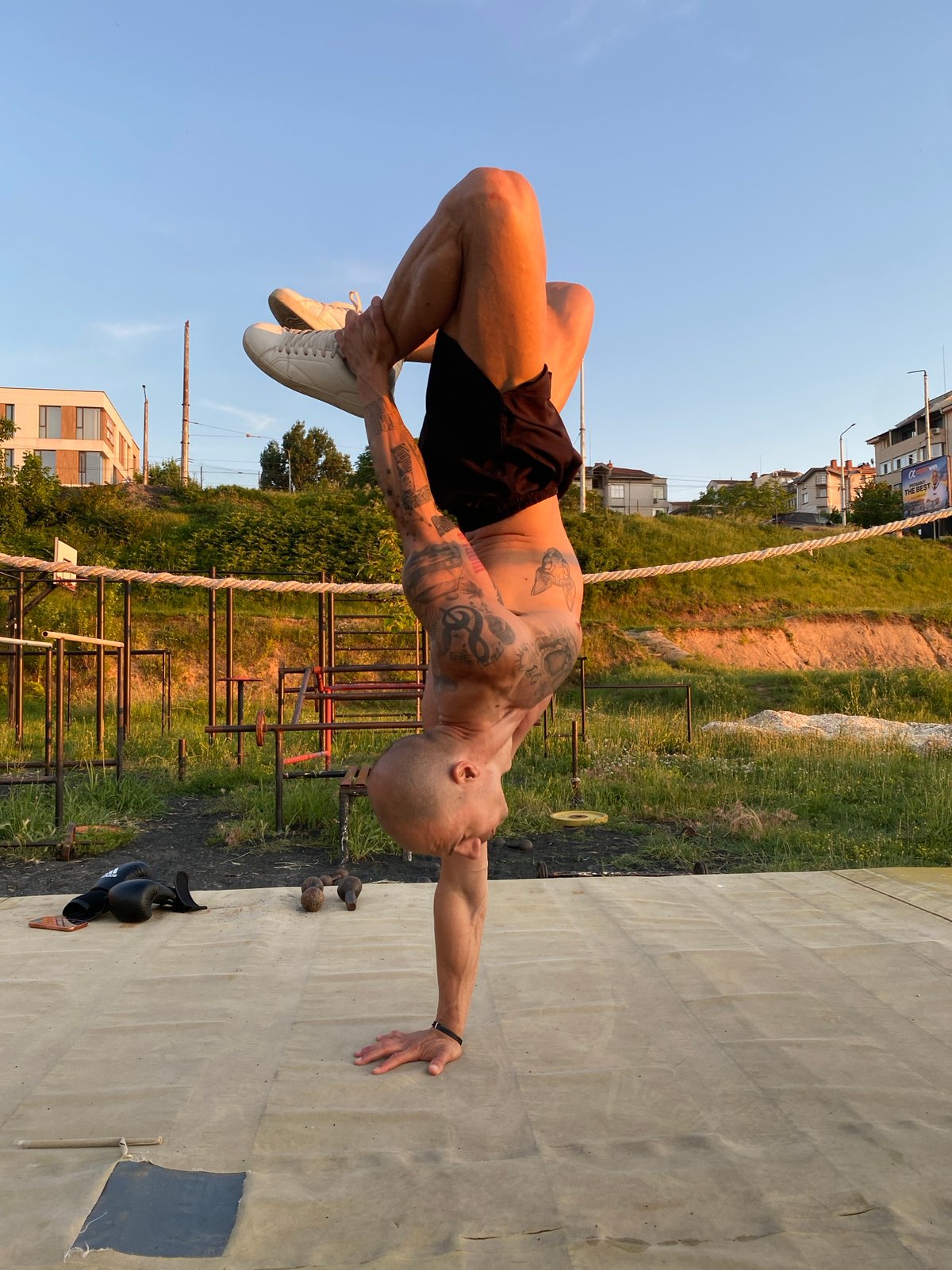 Tattooed athlete trains boxing and handstands in Pleven