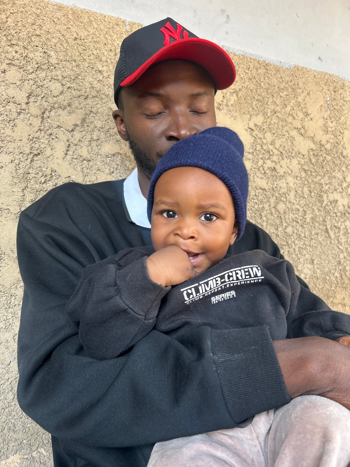 Holding a baby outside in Jos, Nigeria