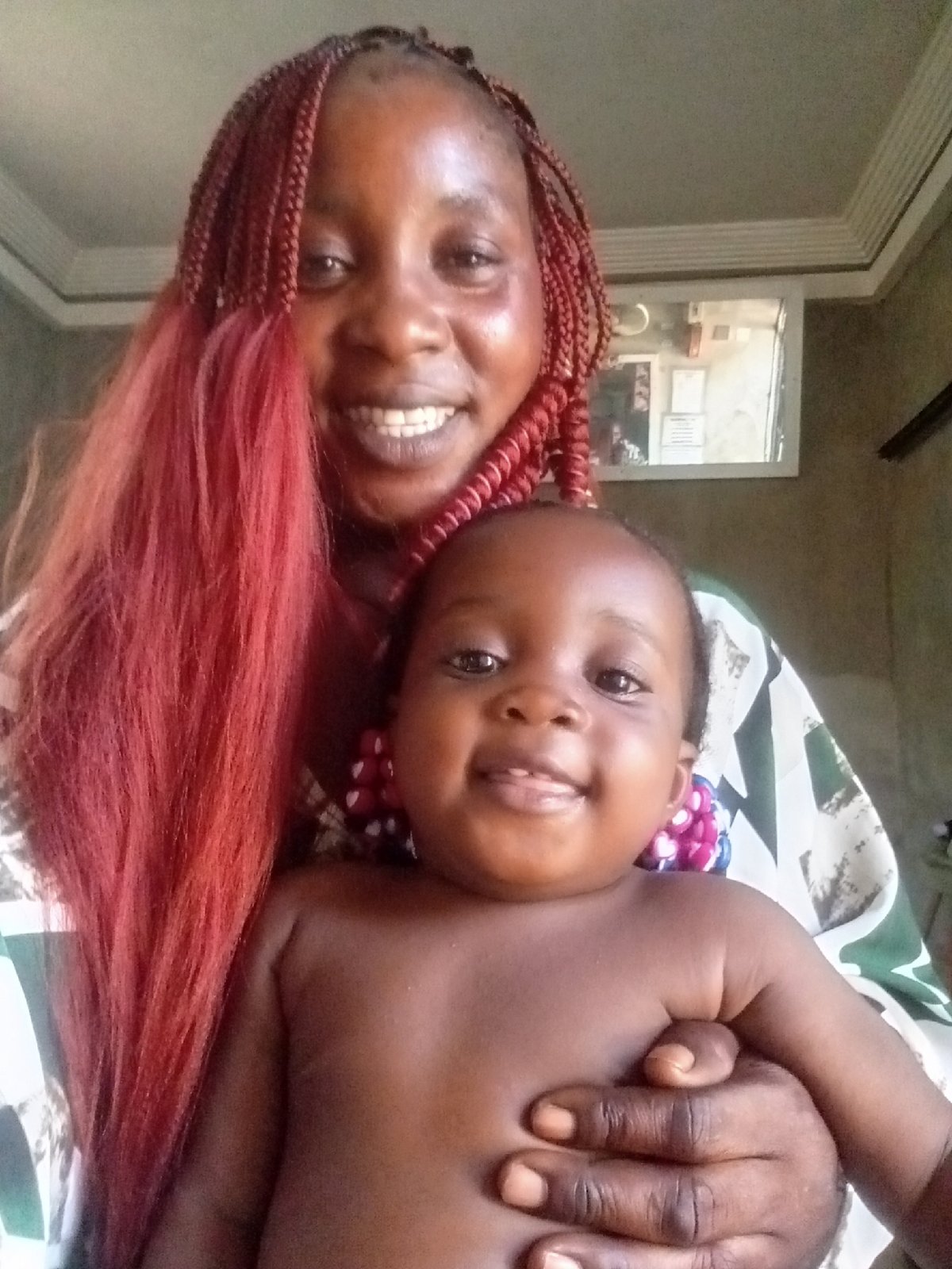 Woman with red braids holds baby in indoor portrait