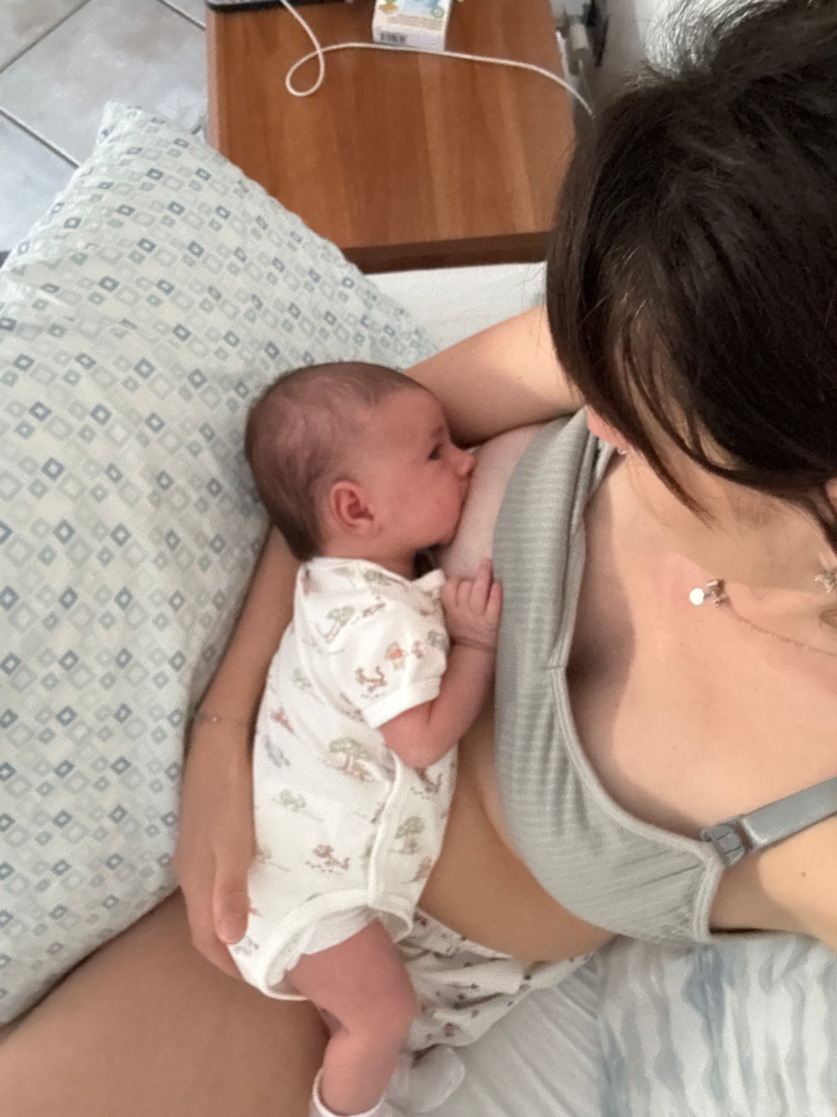Mother breastfeeds newborn baby in early morning intimate moments