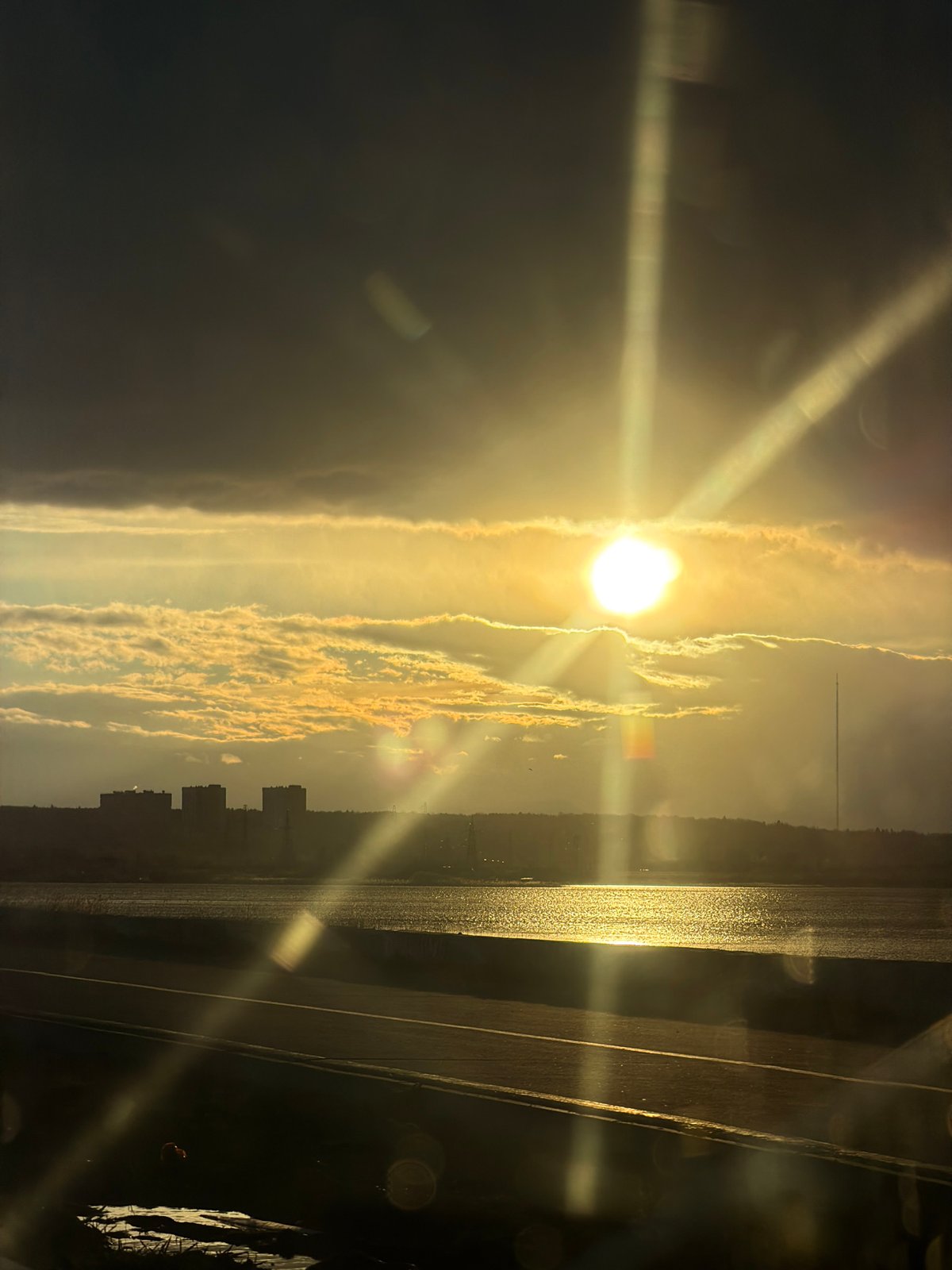 Sunset captured over Izhevsk Pond with city skyline silhouette