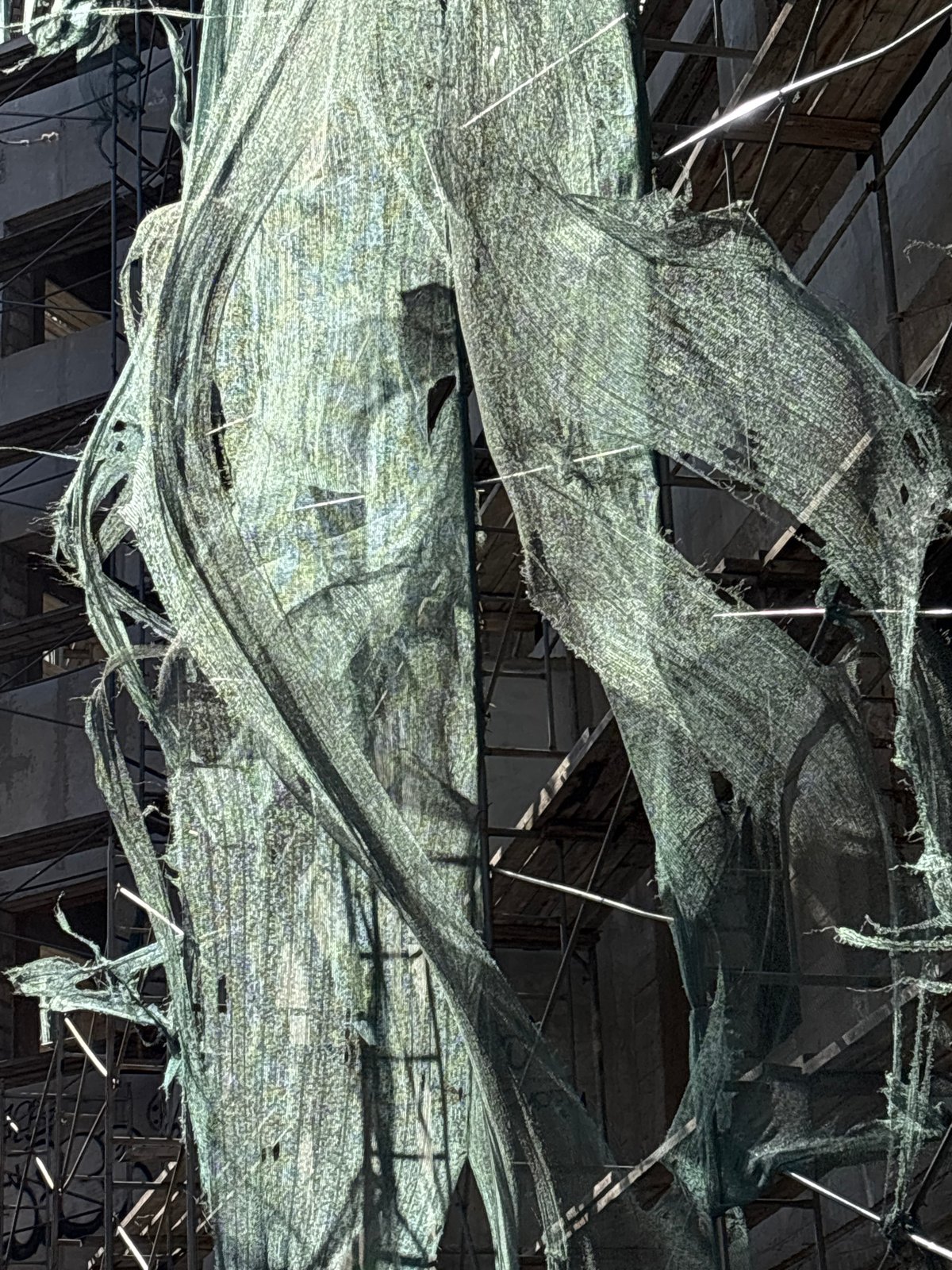 Torn green construction netting documented at renovation site
