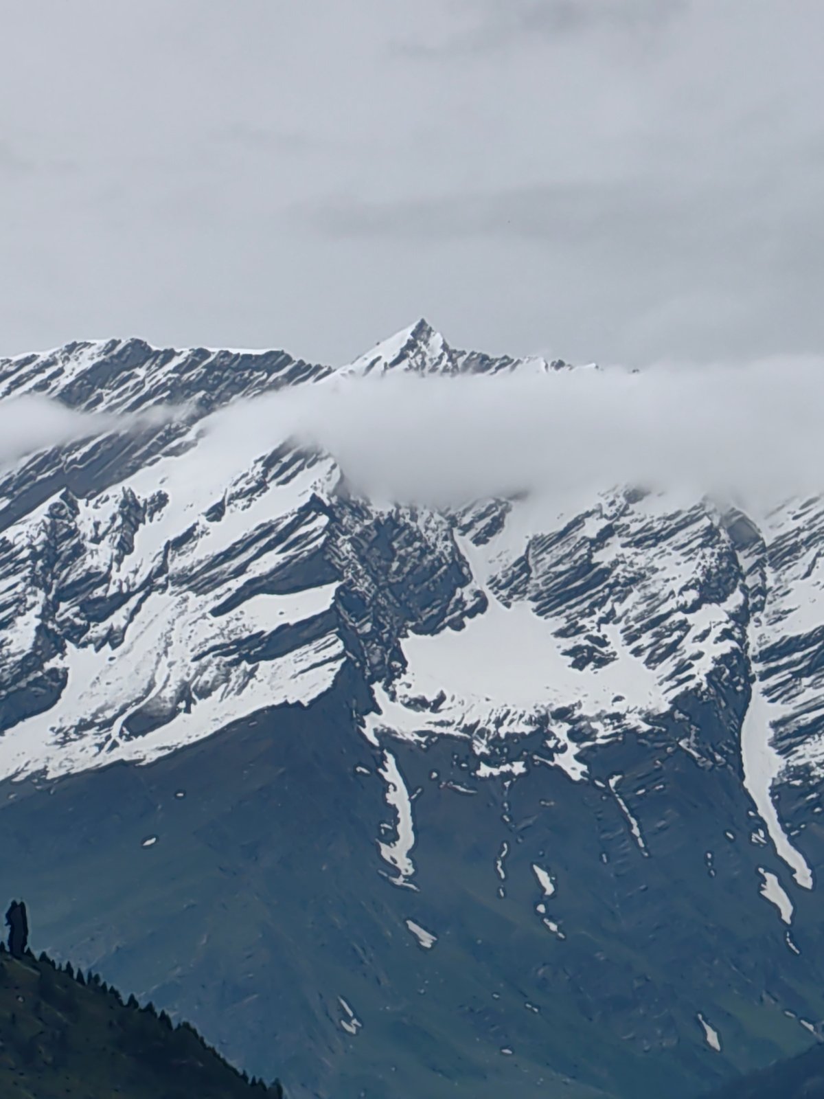 Snow-capped peaks observed through clouds in Vashisht, India