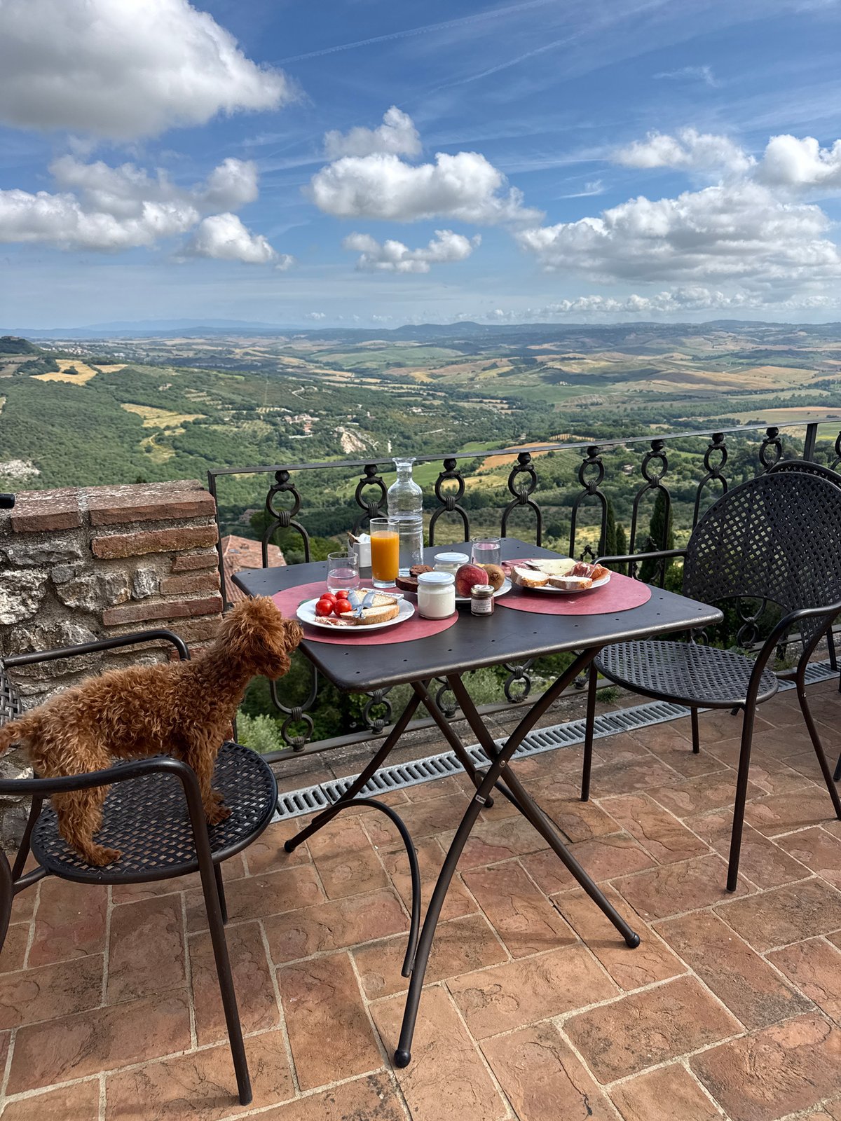 Couple enjoys breakfast on Tuscan terrace overlooking Val d'Orcia