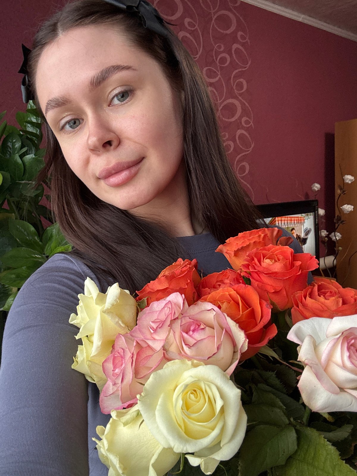 Woman poses with colorful rose bouquet in Dubrova, Russia