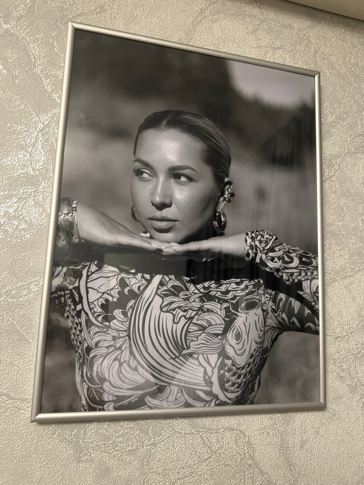 Framed black and white portrait photograph on a textured wall
