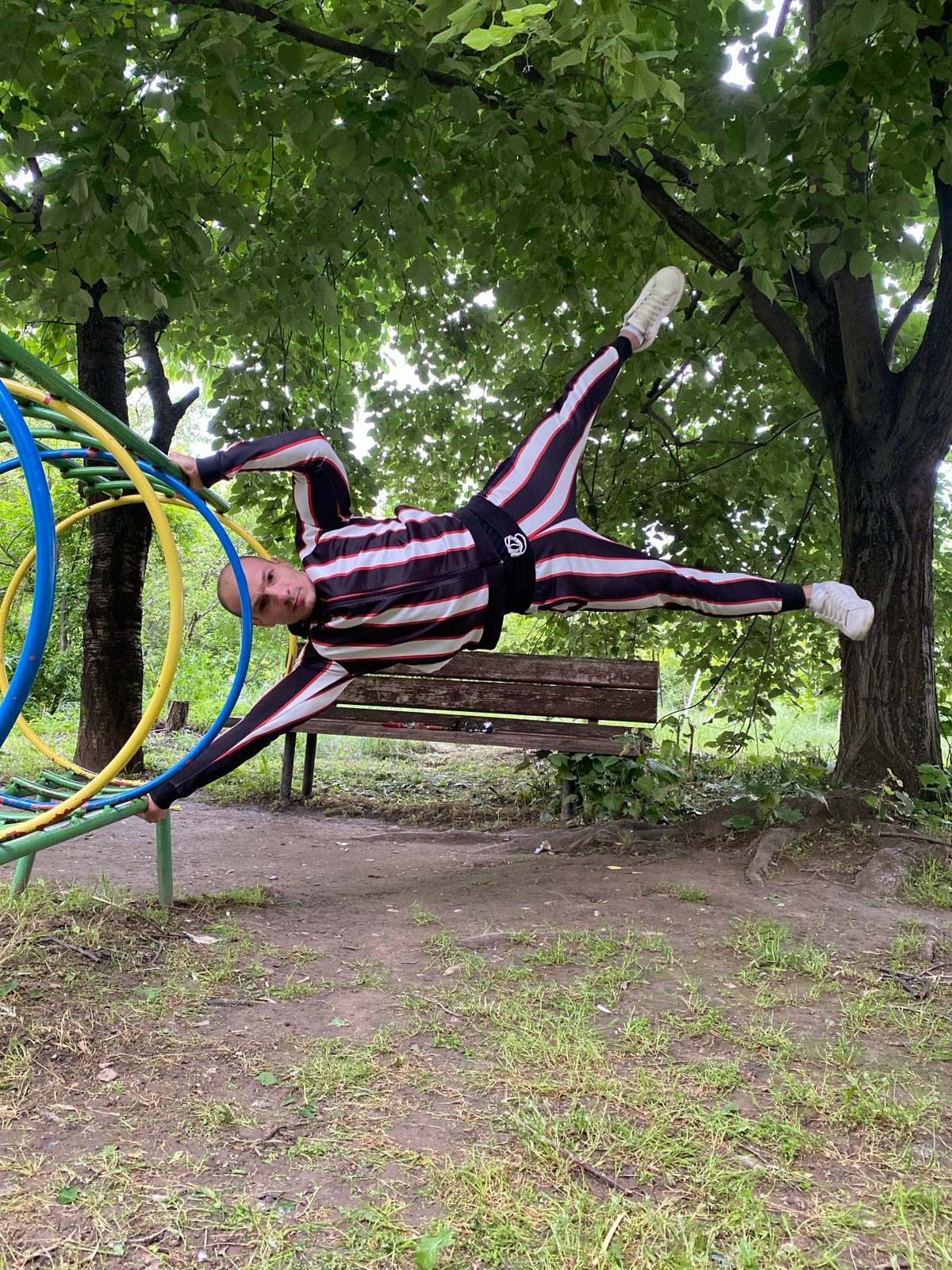 Man performs handstand on colorful playground equipment in Pleven park