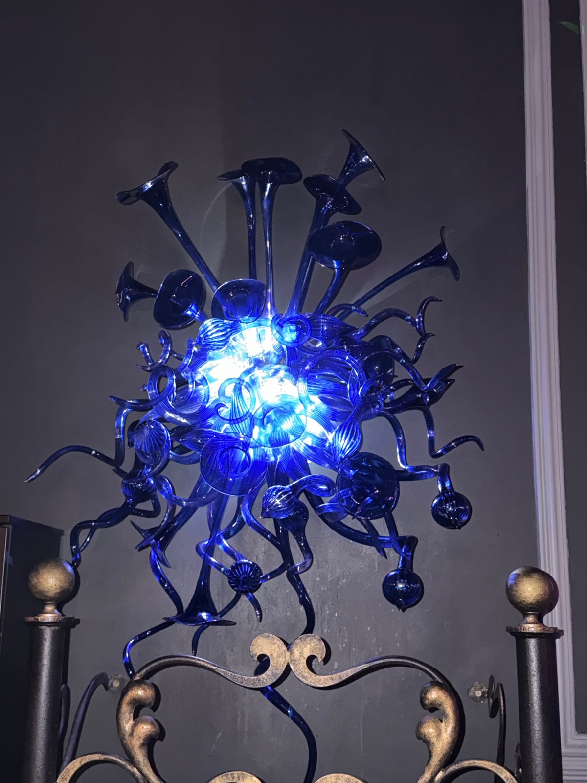 Indoor venue features illuminated chandeliers and DJ equipment signage