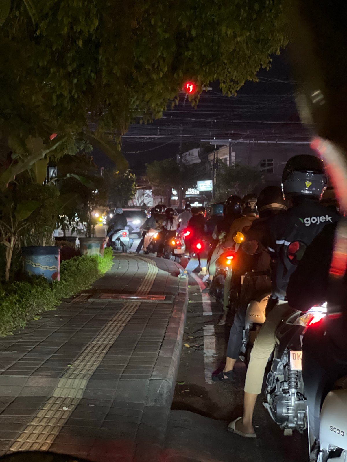 Motorcycle traffic backed up at a Denpasar intersection at night