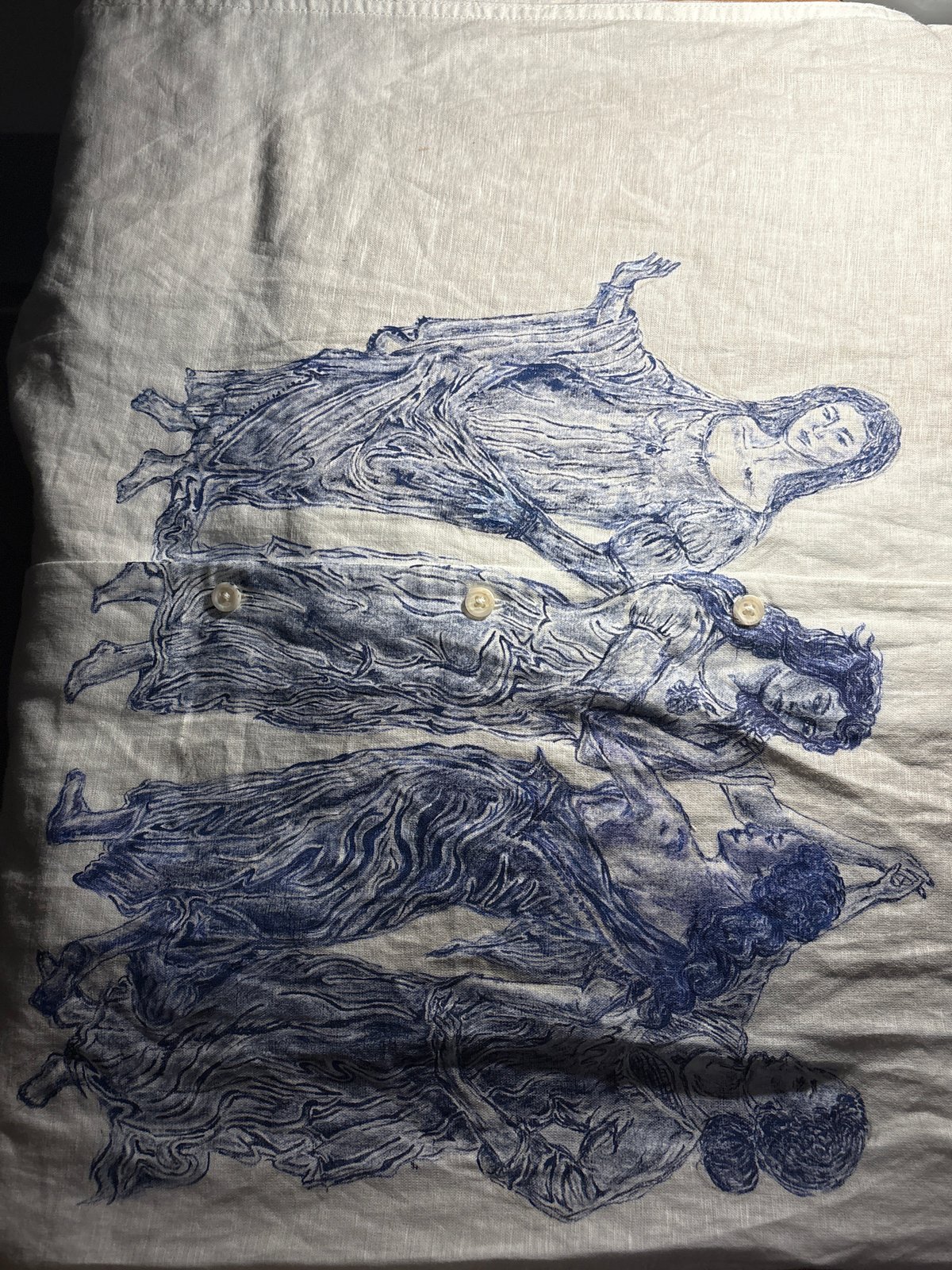 Blue-ink female figures artwork spotted on fabric garment Manchester