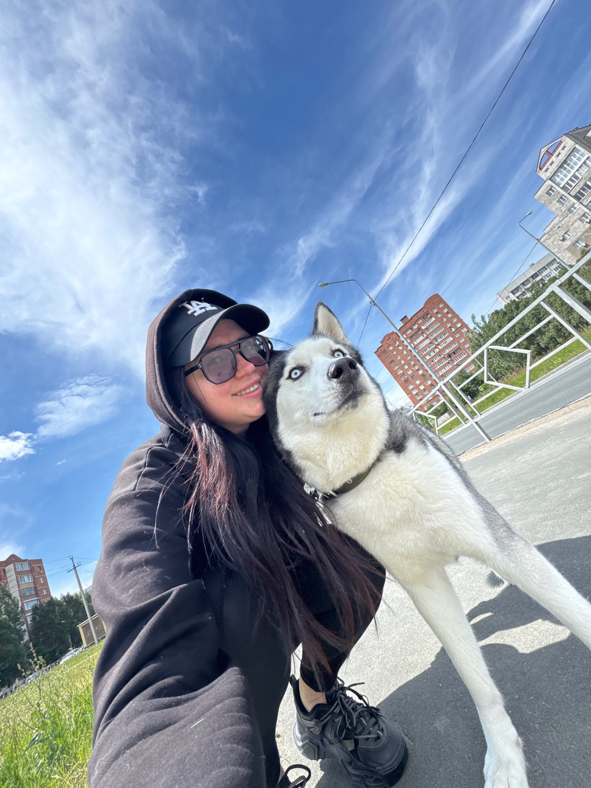 Woman takes selfies with Siberian Husky during morning urban walk