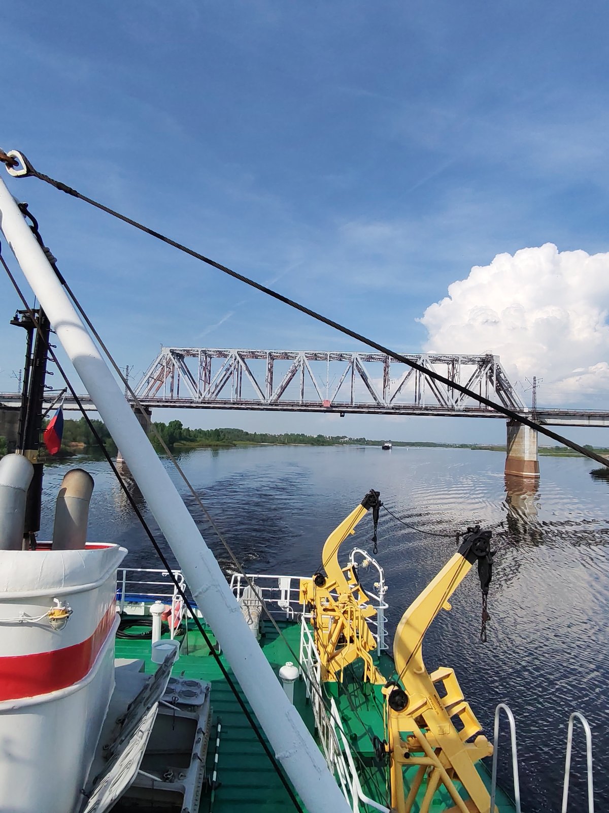 River traffic passes under railway bridge in Russia