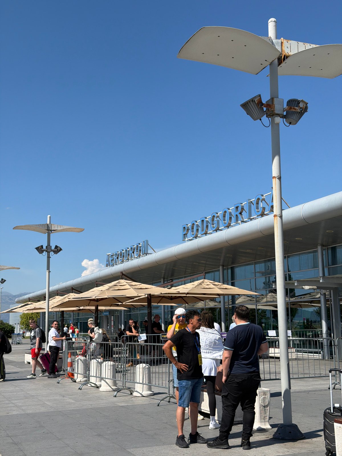 Family travels through Podgorica Airport with distinctive raccoon backpack