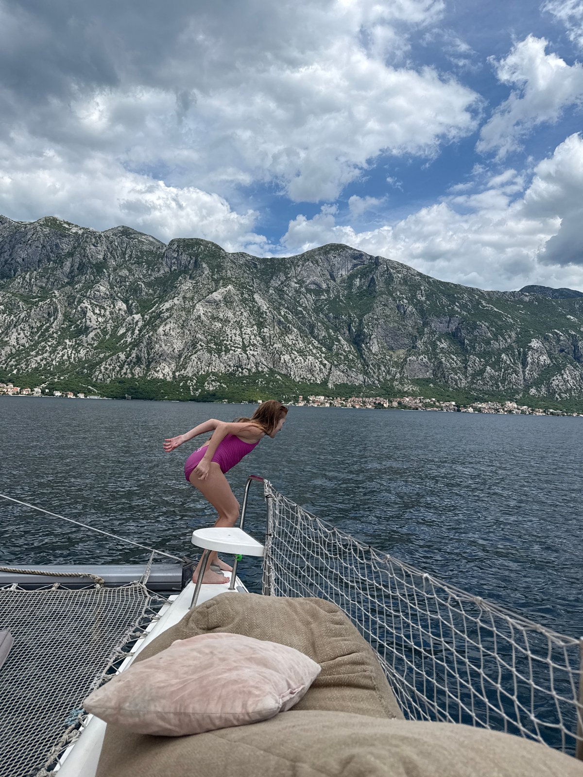 Woman relaxes on sailboat bow in Montenegro waters
