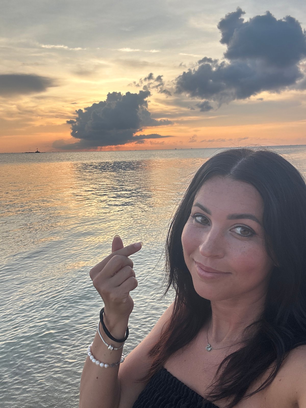 Woman takes sunset selfies on Thai beach
